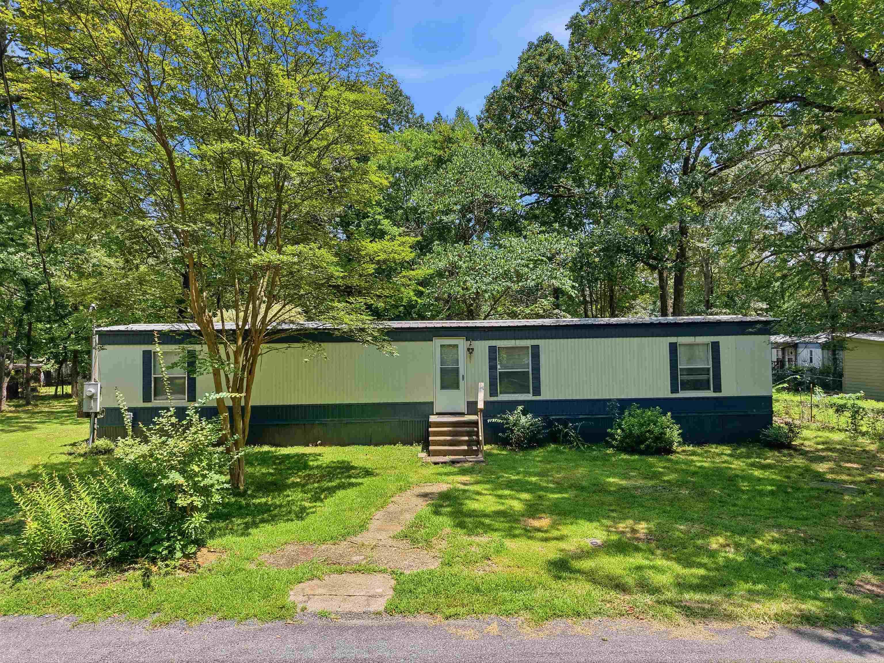 Come see this beautifully remodeled 2-bedroom manufactured home in the Lake Hamilton School District—where affordable living meets lakeside amenities. Nearly 90% of the home has been updated with a new roof, new windows, fresh cabinets and countertops, upgraded fixtures, new heat and cooling, appliances, and stylish 7mm vinyl plank flooring throughout the main areas.    Enjoy a beautifully level, shaded lot with a concrete back patio and outside storage, plus convenient access to the community’s two Lake Hamilton entry points. One includes a boat launch, park, and swimming area—perfect for weekends on the water!  gps pin to the lake access and park area: https://maps.app.goo.gl/u4znH8sYNQfzrXyL6?g_st=ac Disclosure:  Lake Photos shown here are of the Lake Park located 2 blocks away from this home for sale.