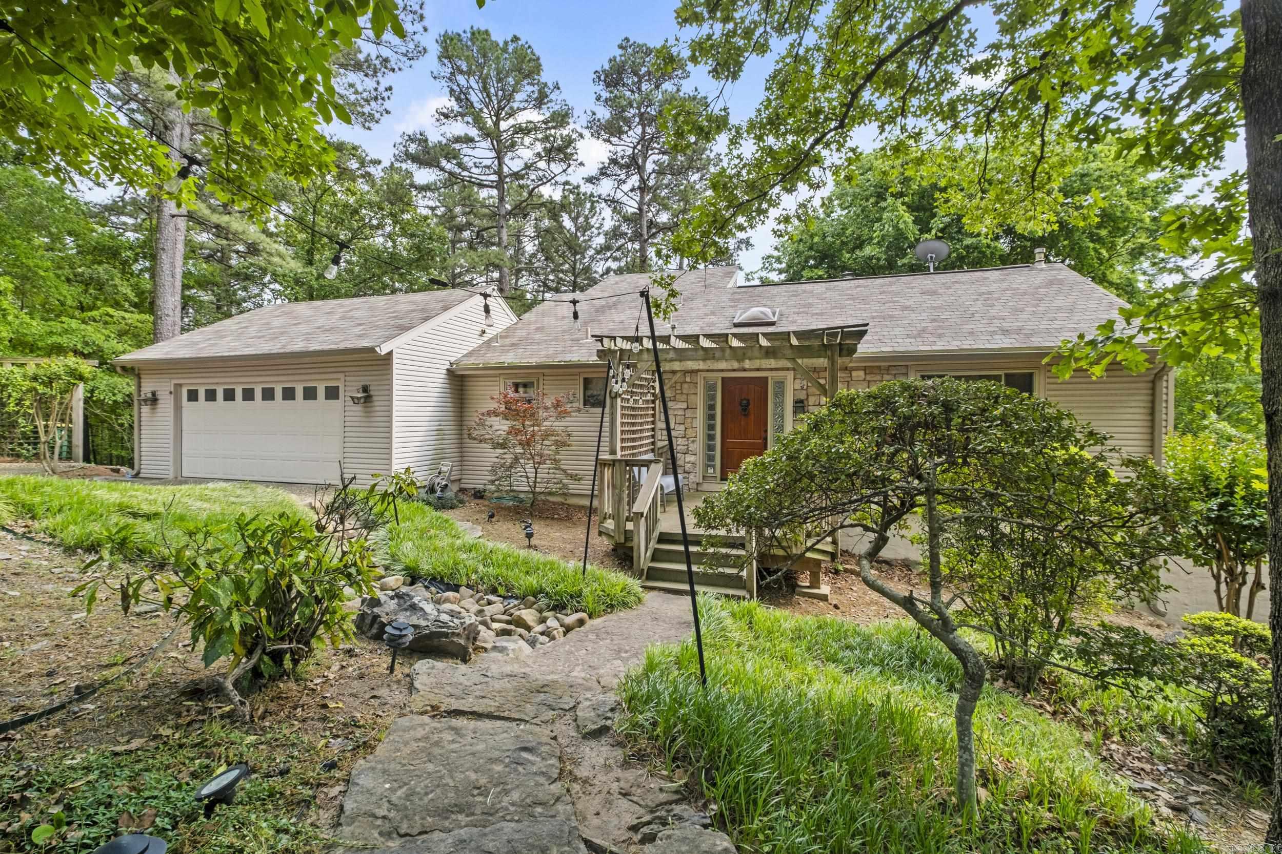 Escape to your own private sanctuary. This stunning home is nestled on over half an acre, offering a beautiful, park-like setting that provides ultimate privacy and tranquility. A unique multi-level layout featuring 3 bedroom/2.5 baths. An inviting Greatroom serves as the heart of the home, complete with a cozy fireplace (remote-controlled for ease). The main floor also includes a functional kitchen and dining area, and a garage equipped with a built-in workbench.  A dedicated office space overlooks the Greatroom, perfect for those who work from home or need a quiet library nook. All three bedrooms and both bathrooms are situated on the lower level, providing a quiet and cool retreat. Features a 50-gallon gas water heater and newer vinyl windows for improved energy efficiency. Peace of mind comes standard with a 50-year roof.