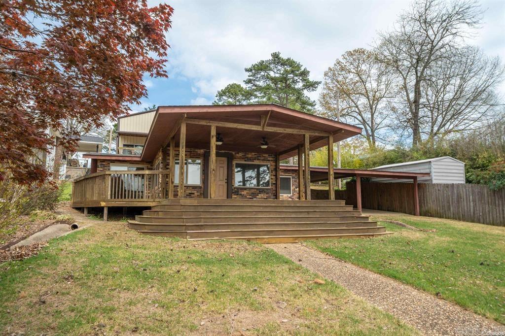 Discover this charming one-level brick lakefront home, perfect as a cozy weekend retreat, a lucrative Airbnb, or a serene full-time residence. Boasting three bedrooms and one and a half baths, this cozy gem offers both comfort and convenience.  Enjoy breathtaking lake views and effortless water access with your very own floating covered boat slip, boardwalk, and lakeside patio—ideal for fishing, boating, or simply unwinding. Recent updates include new energy-efficient windows, a sleek patio door, and modern appliances. Climate control is a breeze with central HVAC and an additional mini-split system, ensuring year-round comfort. Gather around the inviting brick fireplace with gas logs for cozy evenings.  Step outside onto the expansive covered deck, perfect for entertaining or simply soaking in the tranquil lakeside ambiance. The property also features a detached 30' x 42' two-car RV or storage building with impressive 16-foot high walls, two oversized 14' x 12' overhead doors, two patio doors, and its own covered deck with impressive lake views. With plans to convert the upper level into loft-style living quarters, this space is brimming with potential. Additionally, a 12' x 24' w