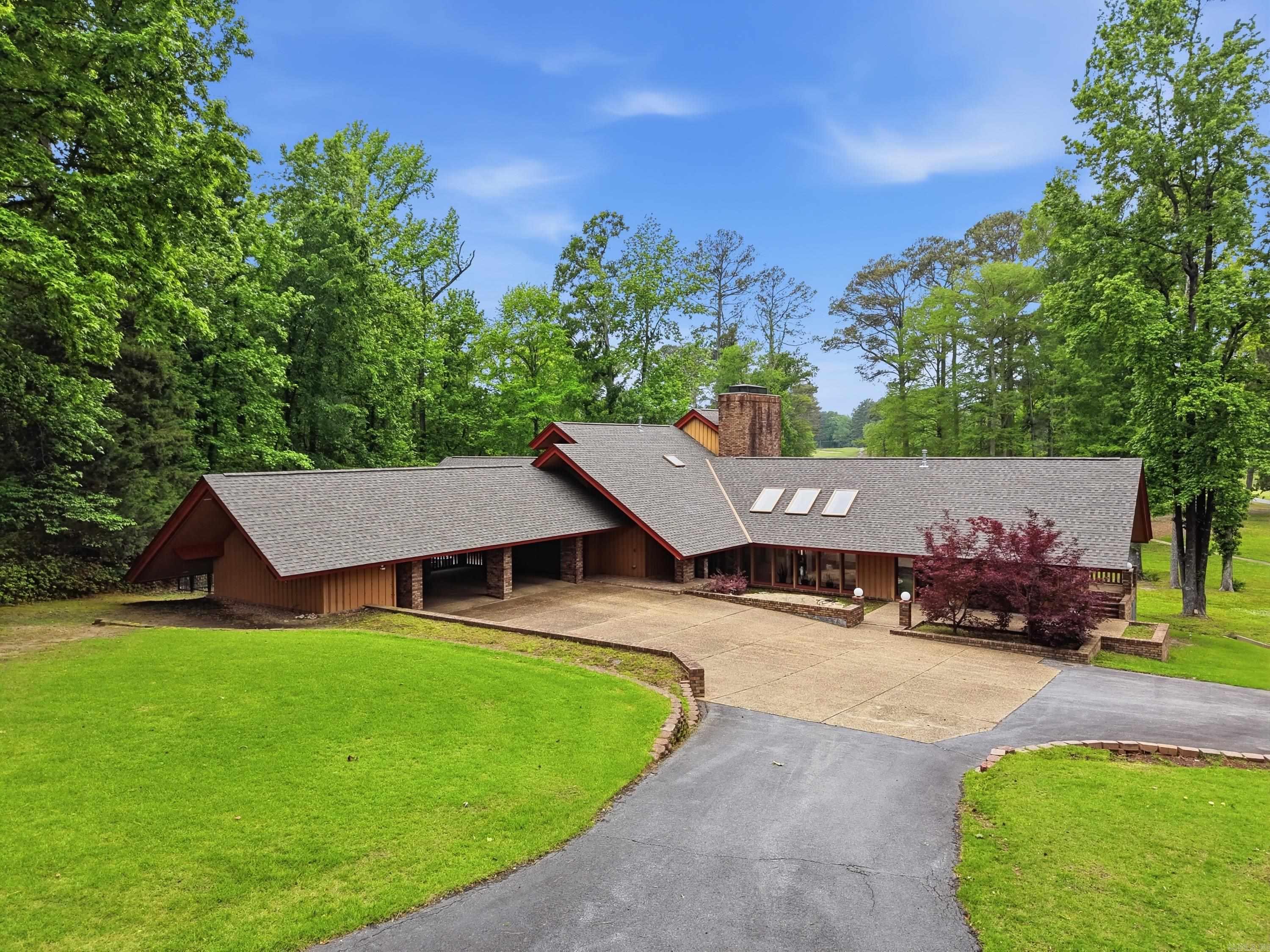 Welcome to 4 Idylwood Drive, a special home where timeless design meets peaceful golf course living. Designed by renowned architect Fay Jones, this mid-century modern retreat sits along Pine Bluff Country Club with beautiful views of the 5th green and 8th fairway. Inside, you’ll find an open layout filled with natural light, soaring cathedral ceilings, and unique fireplaces that create a warm, inviting feel. The remodeled kitchen with its oversized island flows easily into the main living spaces—perfect for gathering with family and friends—while the wet bar adds a fun touch for entertaining. With 4 bedrooms, 3 full baths, and a serene office, there’s space for both everyday living and quiet moments. Wraparound porches invite you to relax and take in the scenery, surrounded by mature trees and a welcoming community. This is more than a home—it’s a place to slow down, connect, and enjoy something truly unique.