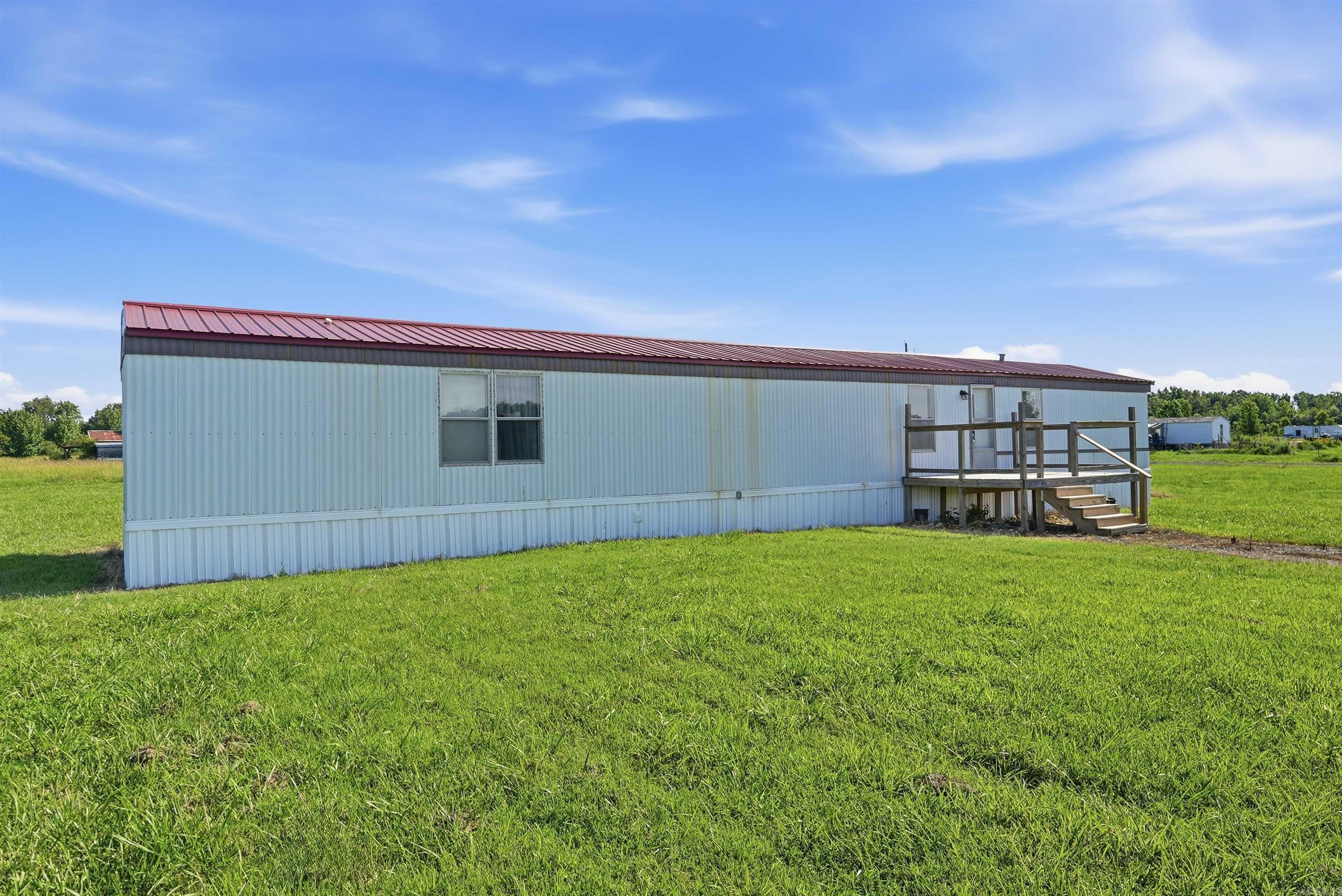 Great home sitting on just over 2 acres with a strong metal roof and on a quiet street! Mobile home title is in the process of being canceled to qualify for mortgages. All systems and appliances are in good working order according to seller. water heater is 15 years old but still going strong. The air handler is nearing 21 years old but still functioning. List price already reflects the age of these systems. Schedule a tour now!