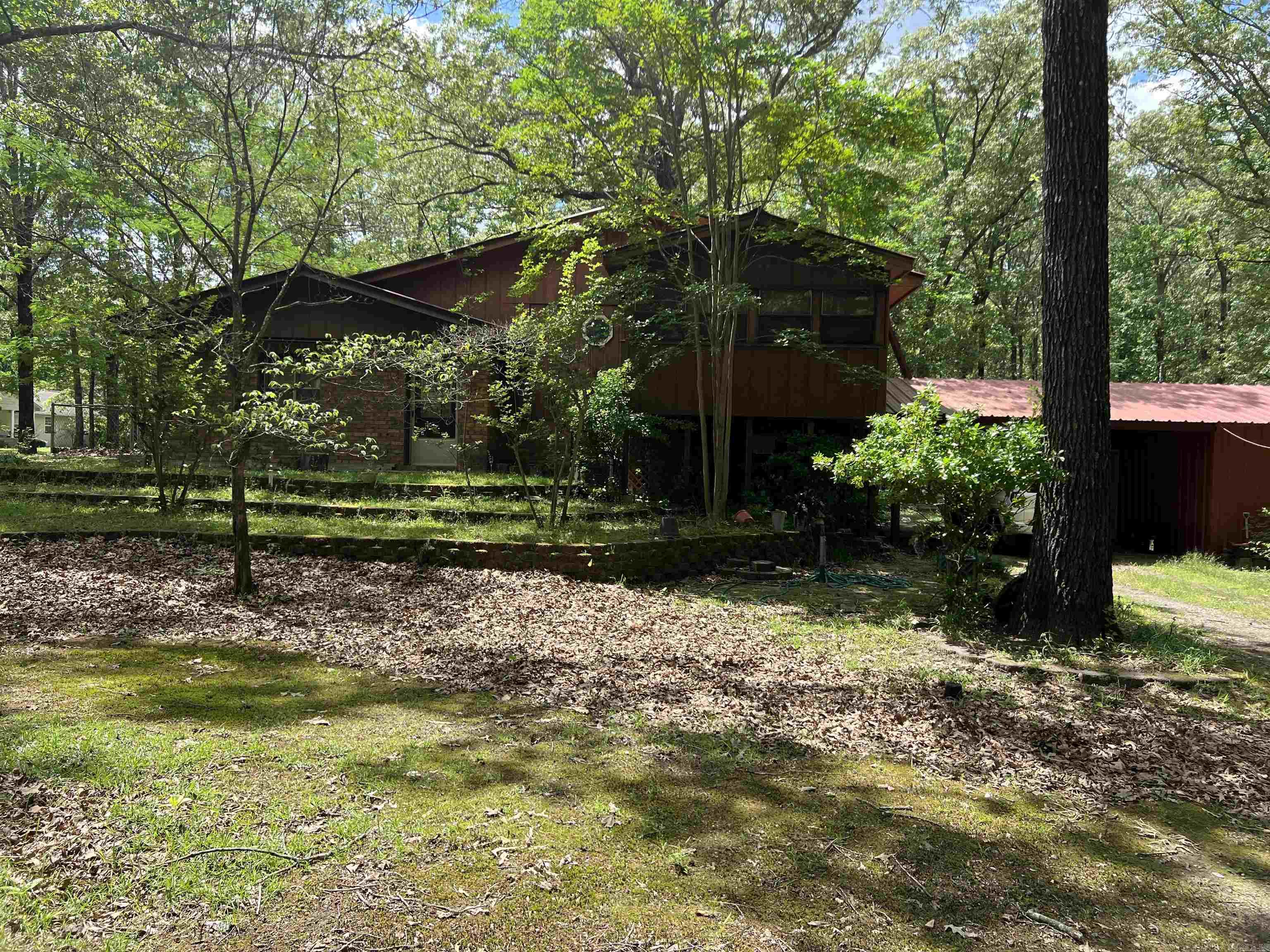 Don't miss this unique as-is investment opportunity! This spacious 2-bedroom, 2-bath tri-level home offers incredible potential for the right buyer. Nestled on just over three acres, this property provides ample space, privacy, and room to grow. The home features a functional layout with a living room and sunroom on the main level, perfect for entertaining or relaxing with a view of the surrounding land. Upstairs, you'll find a versatile bedroom currently being used as a workout room. The bottom level includes a second bedroom, a full bathroom, kitchen, and laundry room/ Additional highlights include a carport with attached storage—ideal for tools, outdoor equipment, or hobby gear. With a bit of TLC, this home could be transformed into a great primary residence, rental property, or weekend retreat. Plenty of potential and land to work with this is an excellent opportunity for investors or handy homeowners!