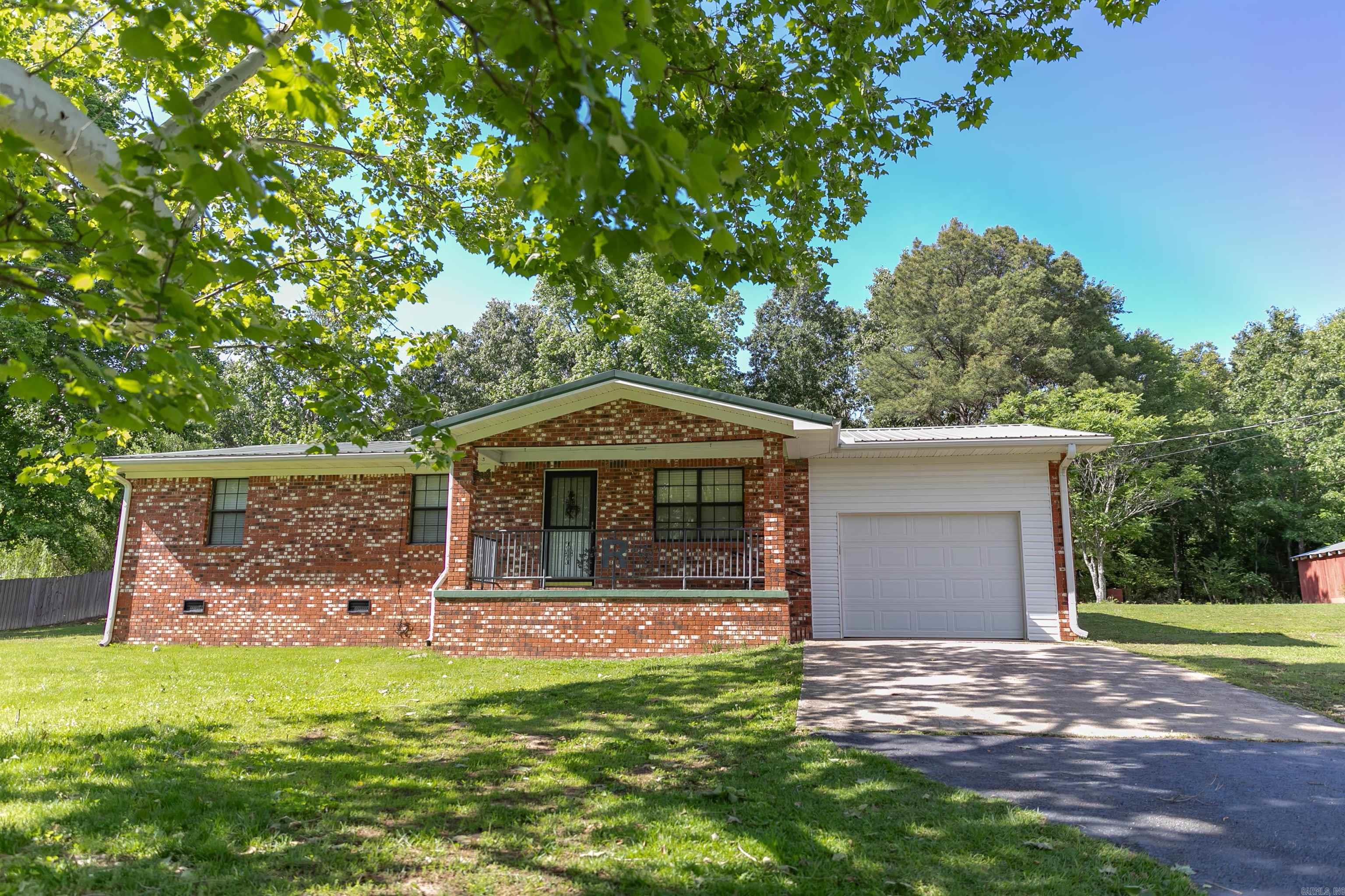 Charming home with a country feel on 1 acre. This home has the open space you're looking for with practical amenities. This well maintained property features beautiful hardwood floors, a durable metal roof, and a spacious one car garage. Outside you will find a large barn, storage shed, and a storm shelter. You'll have plenty of room for hobbies and storage. The peaceful back deck is the perfect place to relax. This property is a perfect opportunity for anyone looking for comfortable country living with still being close to town. Keep the whimsical charm or repaint it's up to you! Agents see remarks.