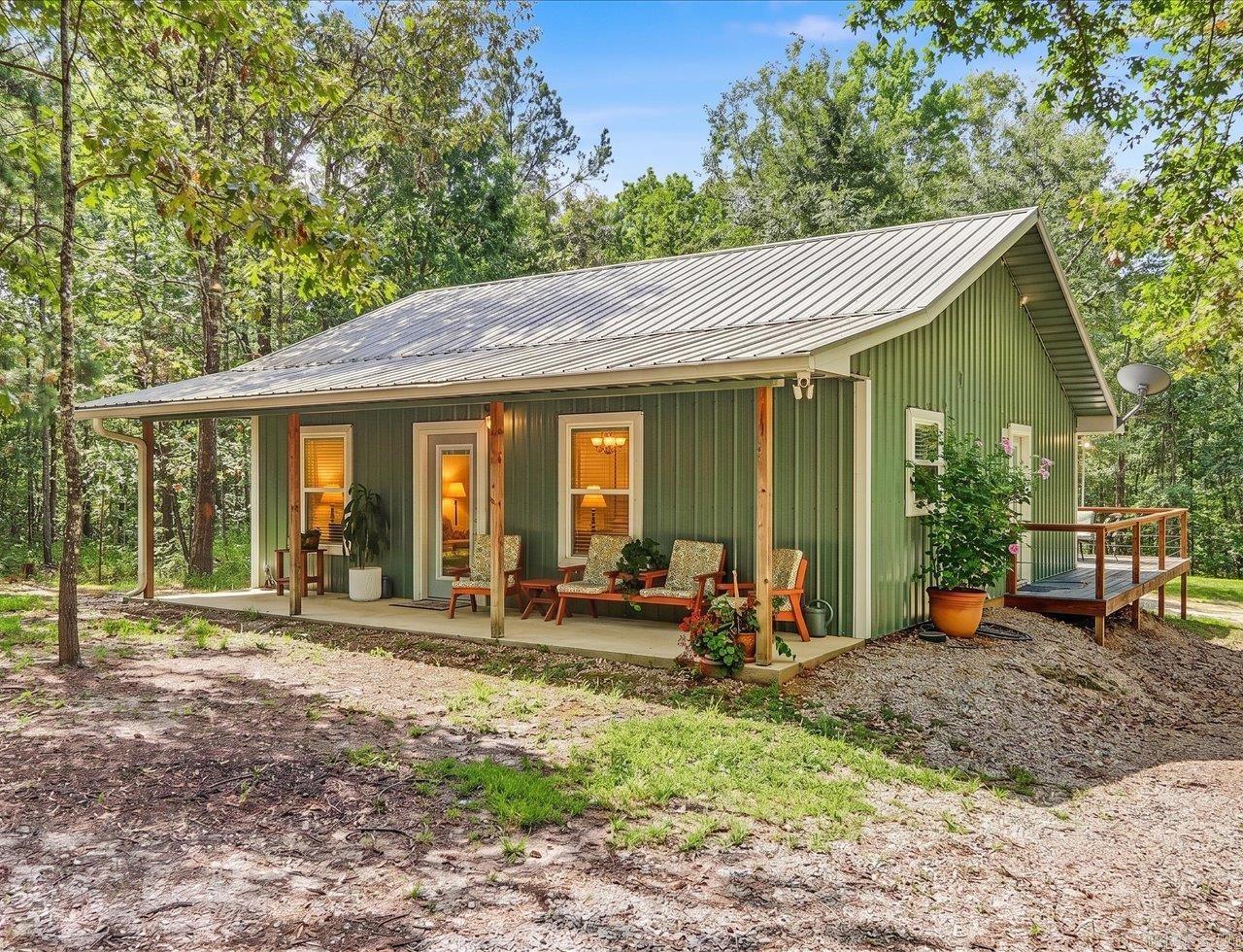 Cottage-style home on approximately 5 acres offering peaceful country living near the Ouachita Mountains. This 3-bedroom, 2-bath home features approximately 900 square feet of efficiently designed living space with granite countertops, stainless steel appliances, and an open, functional layout. A brand-new metal roof and gutters add long-term value and low-maintenance appeal.  Enjoy the outdoors from the covered front porch or the spacious rear deck featuring both wood and composite decking, providing plenty of space for relaxing or entertaining while overlooking the surrounding acreage. A 10' x 16' storage shed offers additional space for tools, equipment, or outdoor gear.  Located near the Caddo River, Sugarloaf Creek, and within easy driving distance of DeGray Lake, Lake Ouachita, and Ouachita National Forest, this property offers convenient access to fishing, kayaking, hiking, hunting, and other outdoor recreation. Approximately 20–25 minutes from Hot Springs, you'll enjoy the privacy of country living with convenient access to shopping, dining, medical facilities, and entertainment.