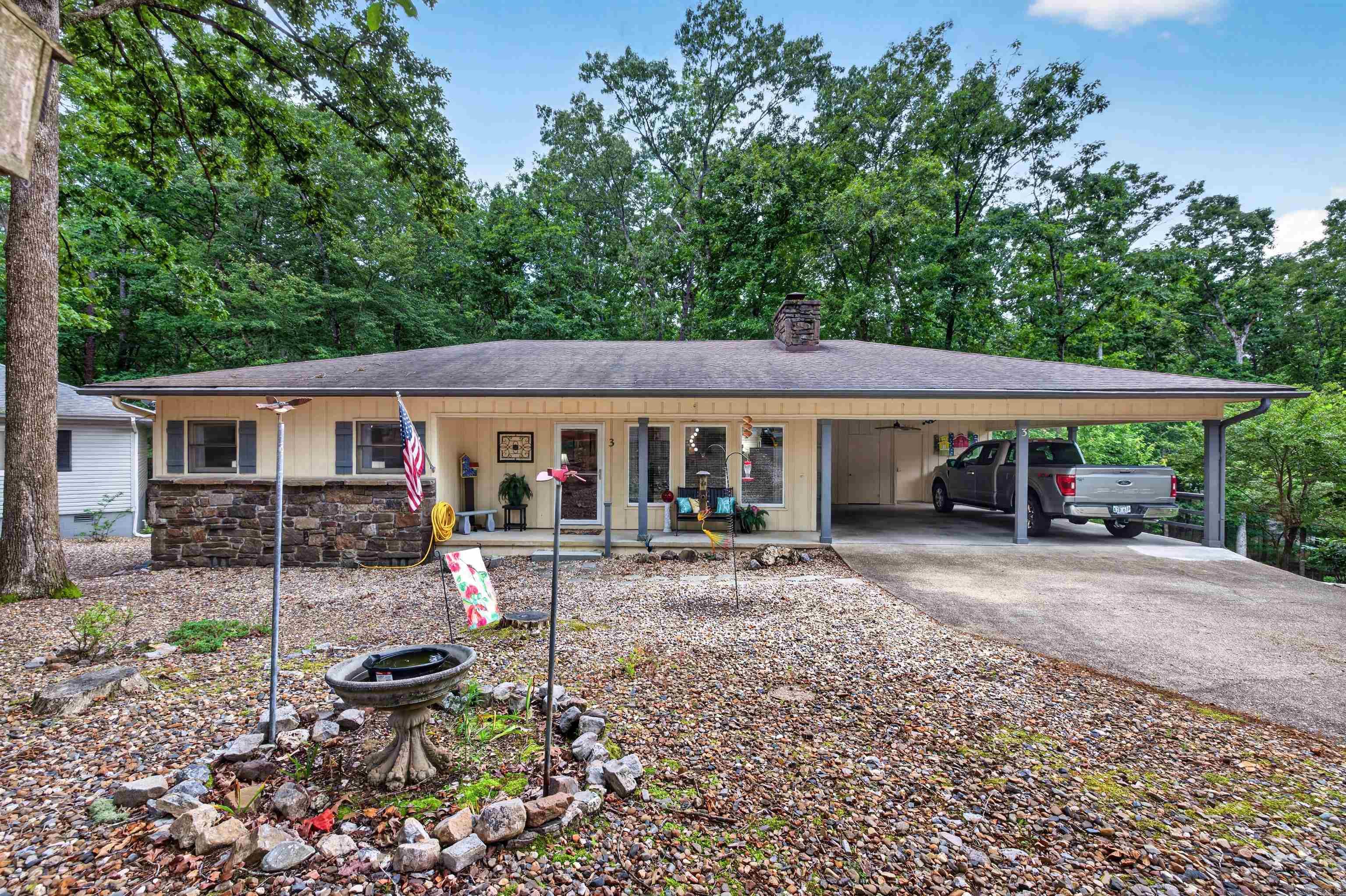 Everything has been done on this exceptional home in popular Hot Springs Village.  Heat Pump, water heater and appliances are 4 years old.  Roof 8 years. Newer windows in living room, newer LVP throughout, whitewashed stone on fireplace, newer front door w/storm, closets rebuilt.  Baths remodeled with new vanities and marble counters, comfort height toilets, primary bath enlarged with large walk in shower.  Kitchen refinished with quartz counters, tile backsplash, double oven range, stainless appliances and microwave.  Laundry room houses pantry. Ceiling fans all new, crawl has vapor barrier on entire level. Attic has added blown in insulation.  Workshop off two car carport is 7 x 16 and there is an additional storage space. This home is immaculate and has been well loved. Deck off back of home overlooks wooded commons area. There is nothing to do but move in and relax.  The Village is a 26,000-acre gated community with 11 lakes, 9 golf courses, pickle ball, tennis, 40 miles of hiking trails, indoor and outdoor pools, pocket play grounds, fitness center, two marinas and white sand beach with covered picnic tables, fishing pier, volleyball and playground.