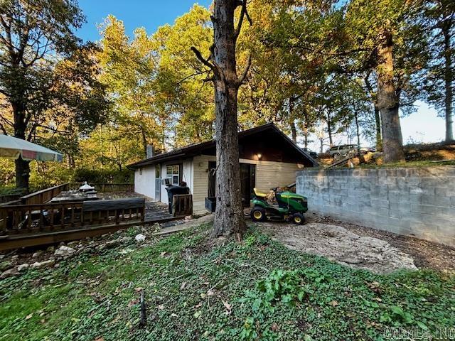 Tucked into the hillside and surrounded by peace and quiet, this super energy-efficient home offers charm, warmth, and scenic wooded views. Inside, the open floor plan features a vaulted living room ceiling with exposed wood beams and a cozy gas stove set on a rock hearth. The kitchen opens to the dining area and includes a breakfast bar, generous counter space, and brand-new appliances (2024). The remodeled bathroom features a walk-in shower. Step outside to enjoy the 16x40 deck overlooking the tranquil acreage. Property includes a 20x20 wired shop and a metal roof that’s only 6 years old. A retreat that’s practical, comfortable, and full of character.