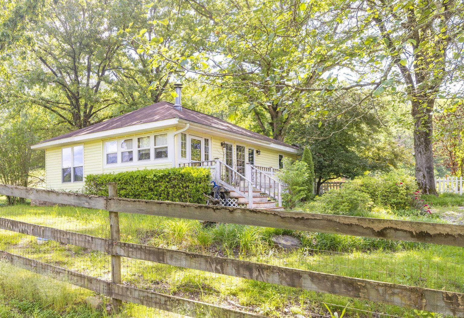This Charming home on 3.5 acres was built in 1920 and lovingly restored in the 90's, much of the original charm has remained! The main home is 1200 sqft, large kitchen, dining and living space that are all open concept, 2bd 1bath with a sun porch and decks on the front and back of the home. Hot tub conveys and overlooks the beautiful hillside.  City water, well maintained septic and two wells on property for your animals and gardens! A tiny home with its own private driveway and gate add so many possibilities to this homestead. Tiny home is fully furnished. The chicken coop is ready for your very own chickens.  Electric gates and fencing up to the tree line. Generac runs on propaine tank, the rest of the home is electric. Foundation has been redone with new beams and piers, floors leveled and the home is move in ready! Whole home warranty being offered by sellers with appropriate offer!