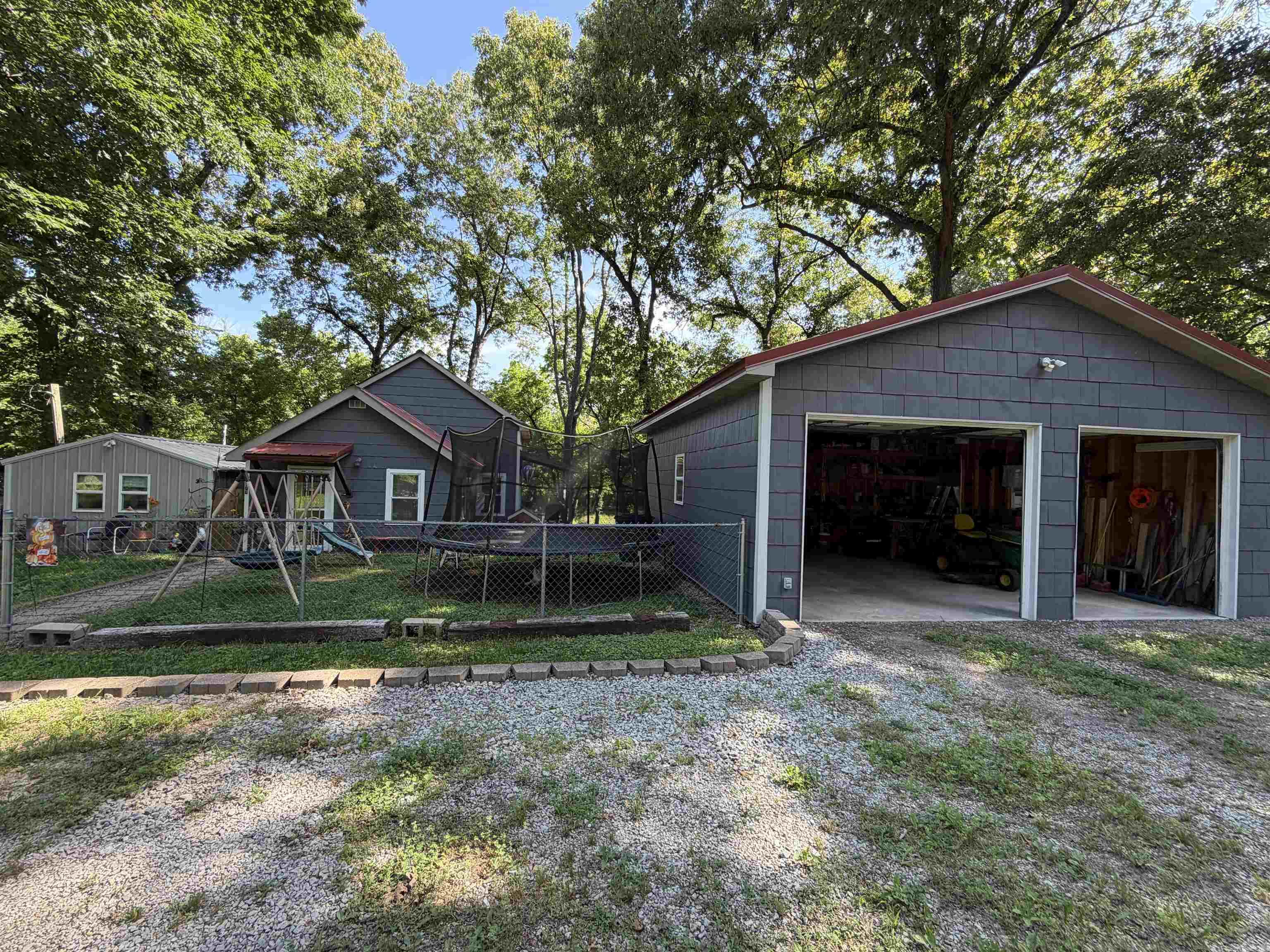 Escape to your own private retreat with this adorable cottage-style home nestled among mature shade trees and surrounded by nature.Approximately half of the property is enclosed with chain-link fencing, offering plenty of space for pets, gardening, or outdoor enjoyment. Theinviting main home features a warm country feel and a spacious deck overlooking a seasonal creek that gently winds behind the property. Enjoyyour morning coffee while listening to birds sing and taking in the peaceful natural surroundings. Inside, you'll find an efficient open-conceptkitchen and living area designed for comfortable everyday living. A convenient utility room with pantry storage helps maximize space. Thedownstairs bathroom showcases a beautiful clawfoot tub, perfect for relaxing after a long day. Upstairs, accessed by a charming windingstaircase, is a private bedroom suite complete with its own full bathroom featuring a shower! Call today for showings!