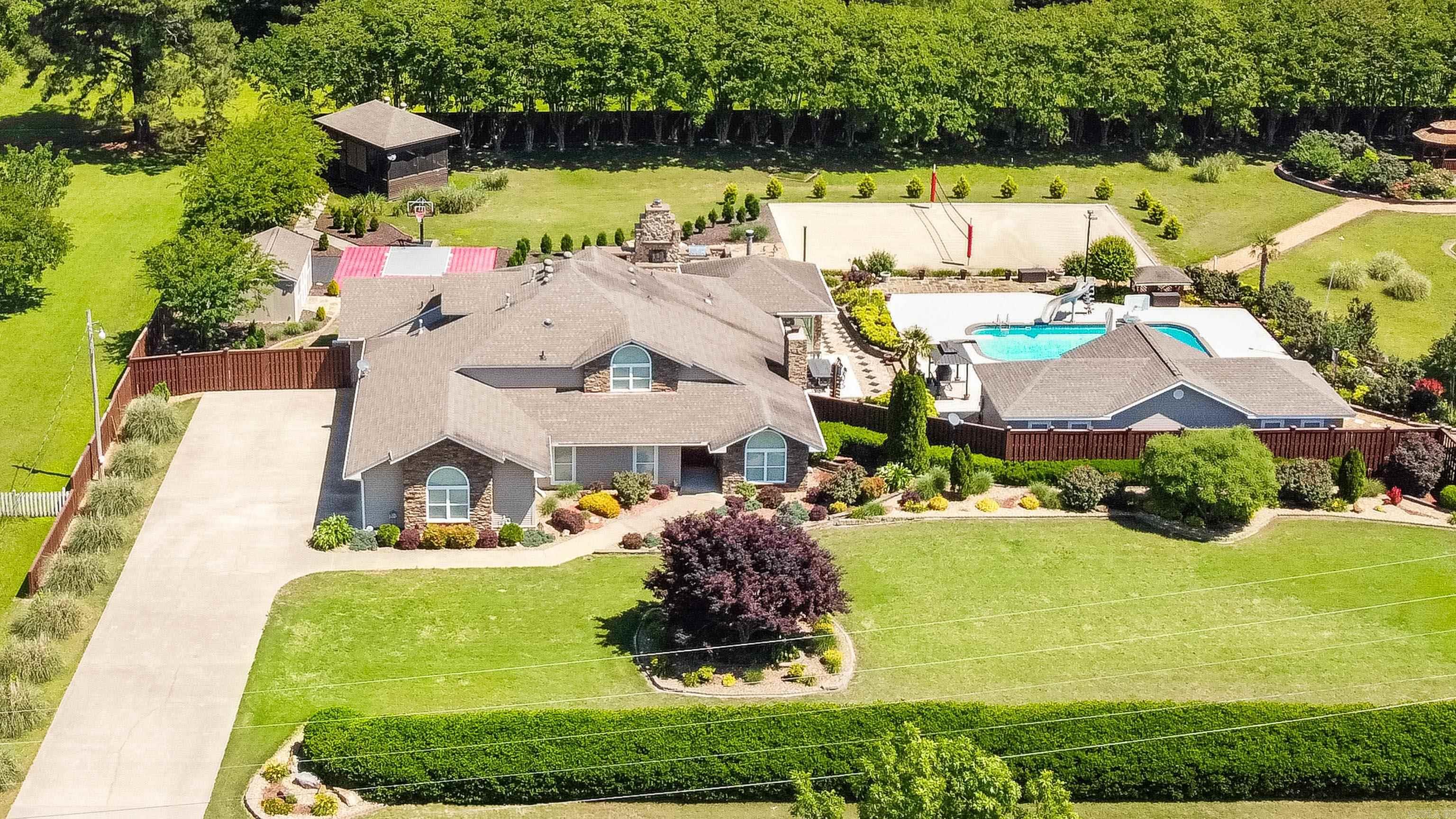 This incredible estate is the ultimate retreat, offering over 4,700 sq ft of thoughtfully designed space and endless entertainment—all in a prime location just 10 minutes from both downtown Benton and Bryant. With three bedrooms (and potential for a fourth), three full baths, and two half baths, the layout includes an office, massive game room, and a stunning sunroom with its own fireplace—all overlooking the backyard oasis. Originally taken down to the studs and completely remodeled in 2008, the home has seen numerous updates since. The remodeled kitchen features a large, curved breakfast bar opening to a spacious family room, while the grand entry boasts soaring ceilings and a cozy wood-burning fireplace. Outside, enjoy resort-style amenities, including a saltwater pool, pool house with kitchenette and half bath, basketball sports court, sand volleyball court, and a private enclosed hot tub or golf simulator area. A storage building with electricity. Every detail has been carefully considered to create a home that blends luxury, comfort, and entertainment. Come experience it for yourself!