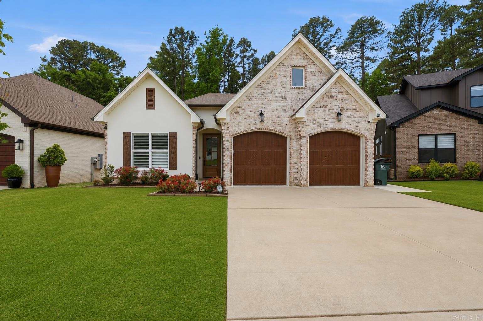 Backing to protected greenspace, this home offers a level of privacy that's becoming increasingly difficult to find for newer homes. Enjoy wooded views & the sounds of nature from the covered rear patio without staring directly into a neighbor's backyard.  Inside, the thoughtfully designed floor plan focuses on how people actually live. The spacious living area flows seamlessly into a well-appointed kitchen featuring an oversized island, gas range, abundant cabinetry, & a walk-in pantry ready for everything from weekly grocery runs to holiday entertaining.  The private primary suite includes double sinks, soaking tub, oversized walk-in shower, & direct access from the primary closet to the laundry room, one of those features you'll appreciate every single day. Generous storage continues throughout the home with a large closet, plentiful cabinetry, & a two-car garage.  And when Arkansas summer temperatures start climbing, you'll appreciate that lawn care is included through the neighborhood dues. No mowing. No spending your weekends battling the heat.  Designed for real life, not just listing photos, this is a home that delivers privacy, functionality, and low maintenance living.