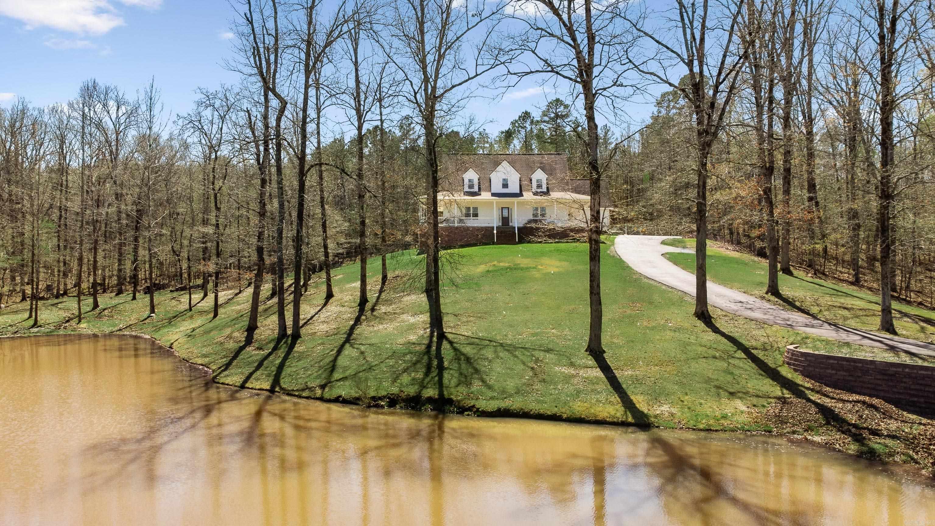 Have you ever wanted to fish in your own front yard?! Imagine your morning coffee on this new porch with this view... Welcome to 1119 Blue Grass Drive, this beautifully loved 3,200+ sq ft Benton home sits on 3.58 acres with a pond, offering peaceful country living on a quiet street, yet not too far from shopping and dining. A rare find in Benton!  This spacious home features a wonderful layout for entertaining with real hardwood floors, extra large living area with tons of natural light, a wood burning fireplace, along with a formal dining room. This home has 4 bedrooms plus 2 bonus rooms with tons of storage throughout. Major updates include new windows, new siding, new gutters, dishwasher, and crawl space encapsulated all in 2024. New carpet upstairs just installed! Enjoy peaceful mornings on the wraparound porch with new concrete and railing overlooking the pond and property. It even has extra covered parking space for your boat or other toys.  A well-loved home ready for new owners to love it just as much. Make your appointment to view today! Agents see remarks for showing notes.