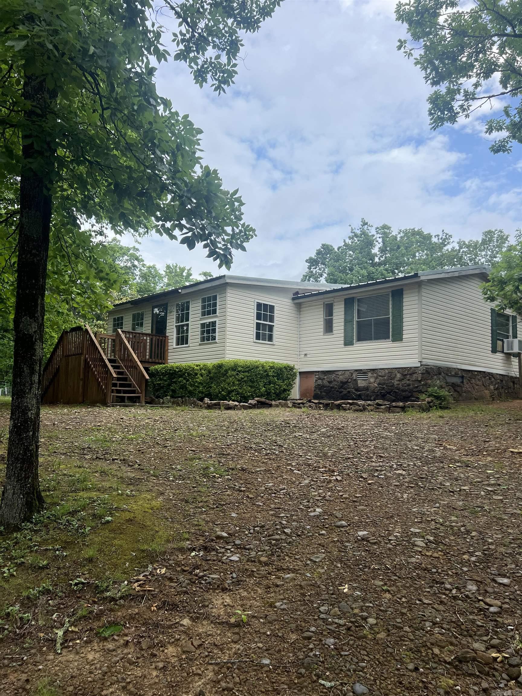 Great home in the country with extra buildings for storage or small farm animals.  3 bedroom 2 bath home with a roomy kitchen, lots of pantry space, new main bathroom and pretty barn doors leading to den. This home has a storm cellar and fruit trees, a big magnolia tree and lots of shade trees.  There is a sunroom on the front and nice screened in porch in the back for enjoying your coffee, the wildlife and the sounds of nature.