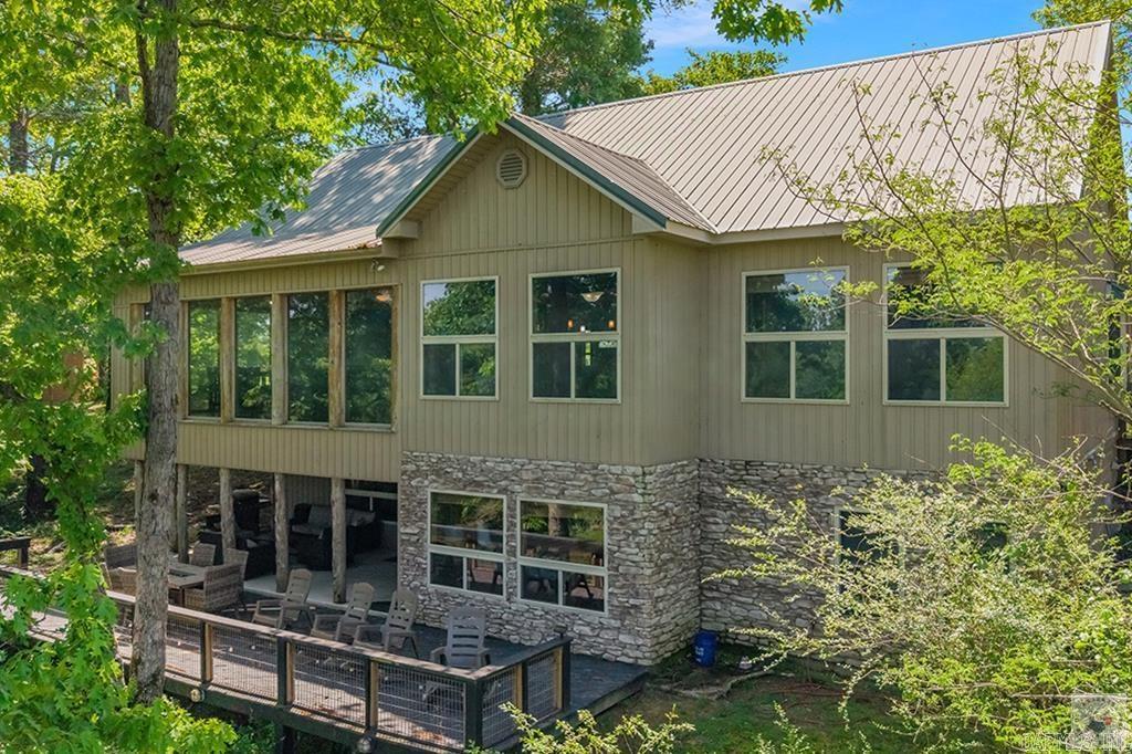 Rarely does a property like this hit the market. Perched above the beautiful Caddo River on 1.6 scenic acres, this custom-built retreat offers luxury, privacy, and unforgettable views in one of the area’s most special settings. Whether you’re searching for a full-time residence, weekend escape, or active short-term rental opportunity, this one delivers. Inside you’ll find soaring vaulted tongue-and-groove ceilings, rich custom finishes, expansive living spaces, and walls of windows designed to bring the outdoors in. The sunroom is a true showstopper with panoramic river views, while the spacious lower-level den opens directly to the patio and deck areas—perfect for entertaining guests or unwinding after a day on the water. The kitchen was built to impress with custom oak cabinetry, granite countertops, generous prep space, and upscale touches throughout. Cozy up beside one of two fireplaces, then retreat to the oversized primary suite featuring a spa-like bath with soaking tub, walk-in shower, and peaceful surroundings. Bonus room offers ideal flex space for office, bunk room, gym, or game room. Outside is where memories are made—multi-level decking, covered outdoor living spaces,
