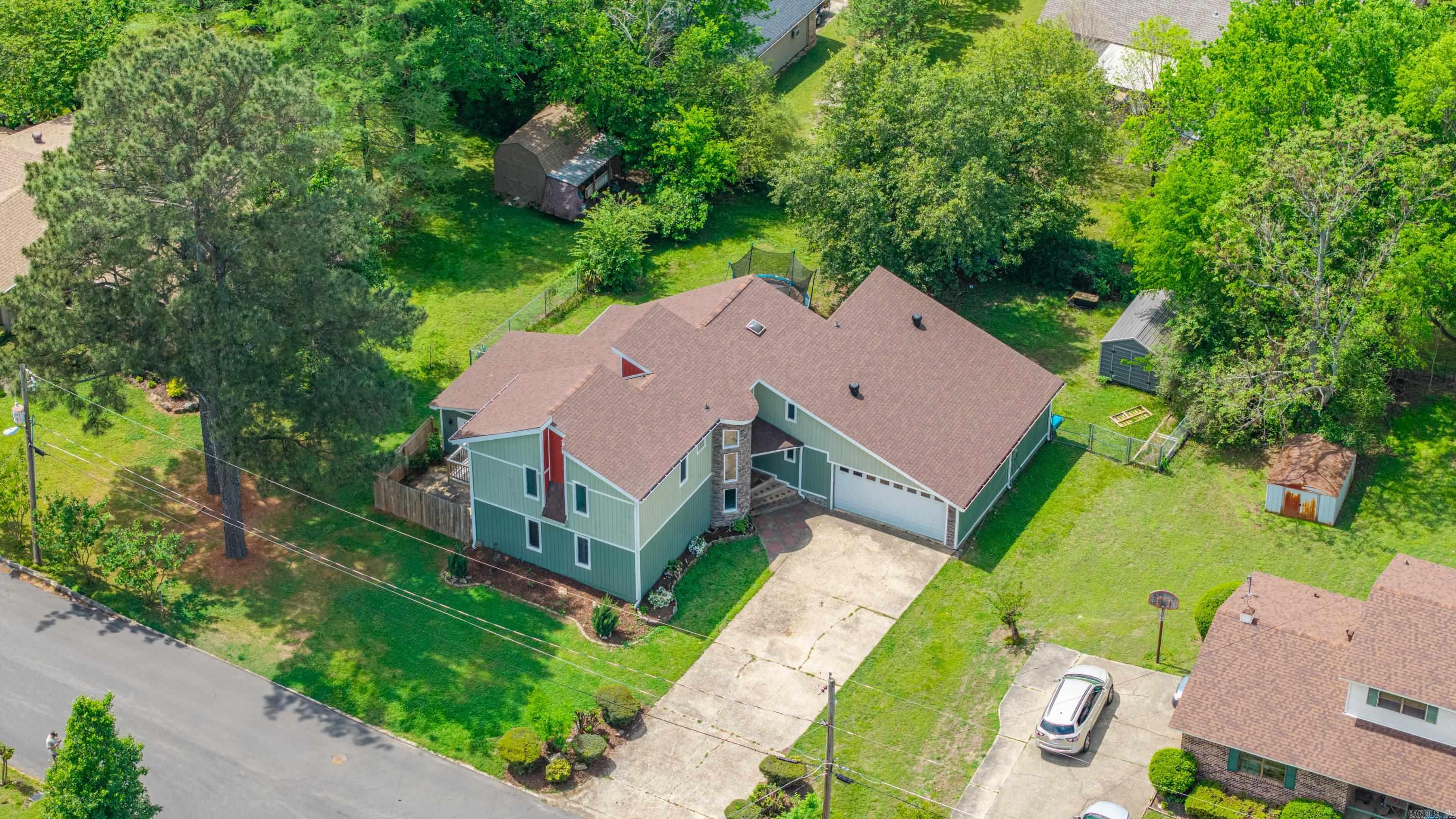 Spacious and full of character, this one-of-a-kind home features an open-concept layout, a striking cupola-style entrance, and multiple outdoor spaces for relaxing or entertaining. Located on a quiet dead-end street just minutes from parks, Oaklawn, shopping, and dining, it offers both convenience and privacy. Inside are 3–4 generously sized bedrooms and 2.5 baths designed for comfortable living. The main living area showcases beautiful stone flooring and a cozy fireplace, creating a warm gathering space. The oversized kitchen provides plenty of room to cook and connect, while skylights and large windows fill the home with natural light. A floating staircase leads to a versatile loft overlooking the living area—ideal for an office, media room, or play space. The primary suite offers a peaceful retreat with an ensuite bath and spacious walk-in closet. Outside, enjoy multiple patio areas, a garage, and an additional storage building. With a newer roof and updated exterior, this home blends unique architectural charm with modern updates—perfect for a large family or anyone who loves to host.