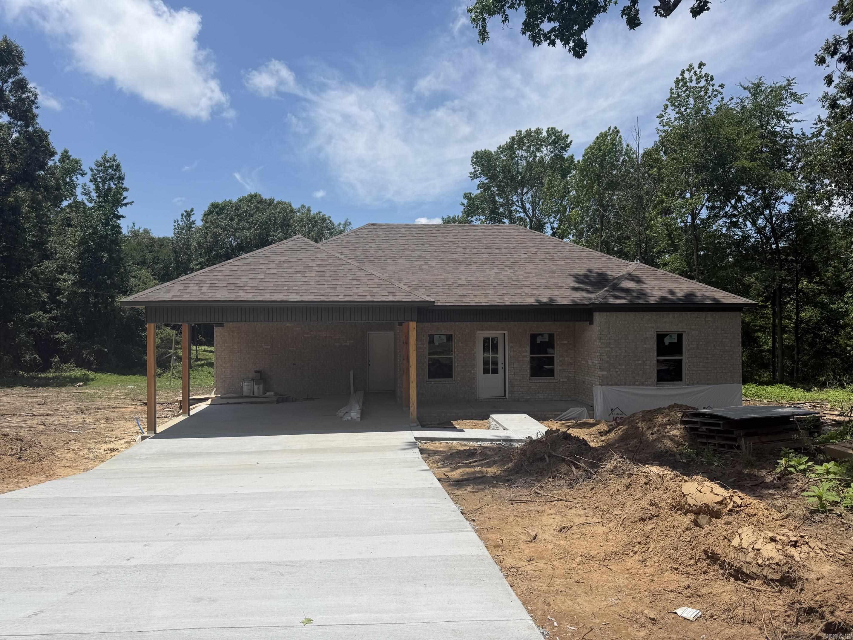 Now under construction, this beautifully crafted new home offers 3 bedrooms and 2 bathrooms with a thoughtfully designed open-concept layout. Nestled on a spacious lot surrounded by mature trees, this property combines modern finishes with peaceful country living.  Inside, you'll find luxury vinyl plank flooring, abundant natural light, and a spacious living area that flows seamlessly into the kitchen and dining spaces. The kitchen is being finished with custom cabinetry, a center island, and ample storage, making it ideal for everyday living and entertaining.  The private primary suite provides a relaxing retreat, while two additional bedrooms offer flexibility for family, guests, or a home office. A covered carport adds convenience and curb appeal.  With quality craftsmanship and stylish finishes throughout, this new construction home is nearing completion and presents a wonderful opportunity to own a brand-new residence in a serene setting. Schedule your showing today and watch your future home come to life!