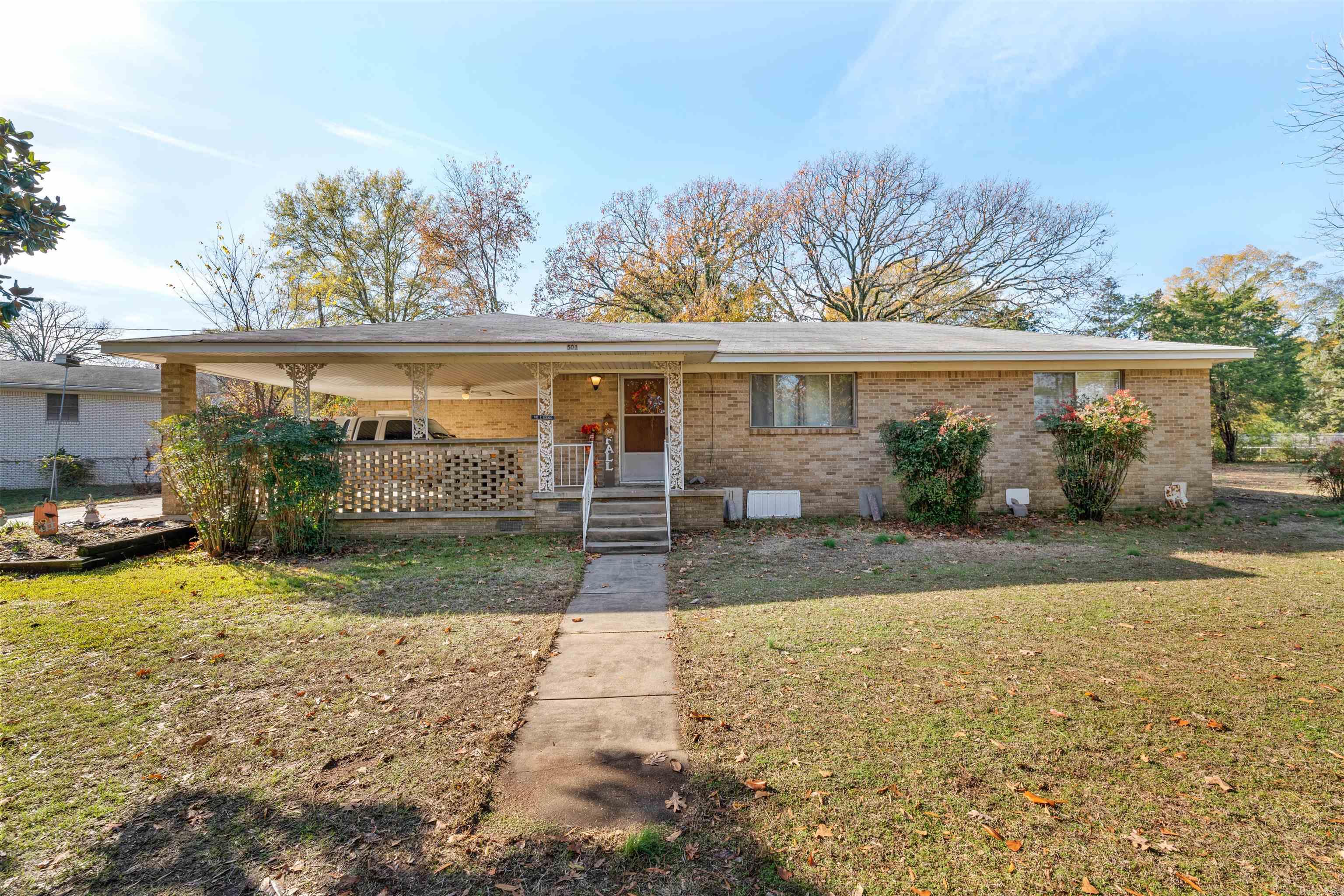 Such a unique, wonderful property sitting on an acre.  Great all brick family home sitting on approximately 1/2 acre lot with approximately another 1/2 acre lot attached. An added bonus to the property is it has 2 pecan trees and one pear tree.  A private drive leads you up to this gem in the middle of the city! You'll love the nice hardwoods throughout most of the home and the updated vintage bathroom.  The primary bedroom has a half bath and a large attached sitting room/nursery/office space or whatever you need! The other 2 bedrooms are spacious with large closets.  Spacious living and dining with a large picture window to the front. There's an additional room off the kitchen to use as a mud room/office space/ or playroom.  Nice double carport and plenty of garden space outside. This home has been in the same family for 64 years. A little TLC will go a long way in making this a wonderful home. See showing remarks for alarm information and measurements are approximate. No disclosure provided. Roof is scheduled to be replaced by end of January. Ductwork was resealed and new insulation was blown in the attic on 12/28/2023.