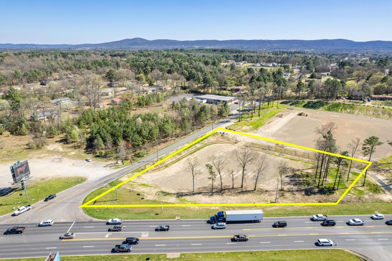 High visible stop light corner with 5 lanes and high traffic counts along busy US Highway 70 W of Hot Springs near Lake Hamilton schools and lots of residential roof tops. City utilities.  Note: Additional land available for additional price.