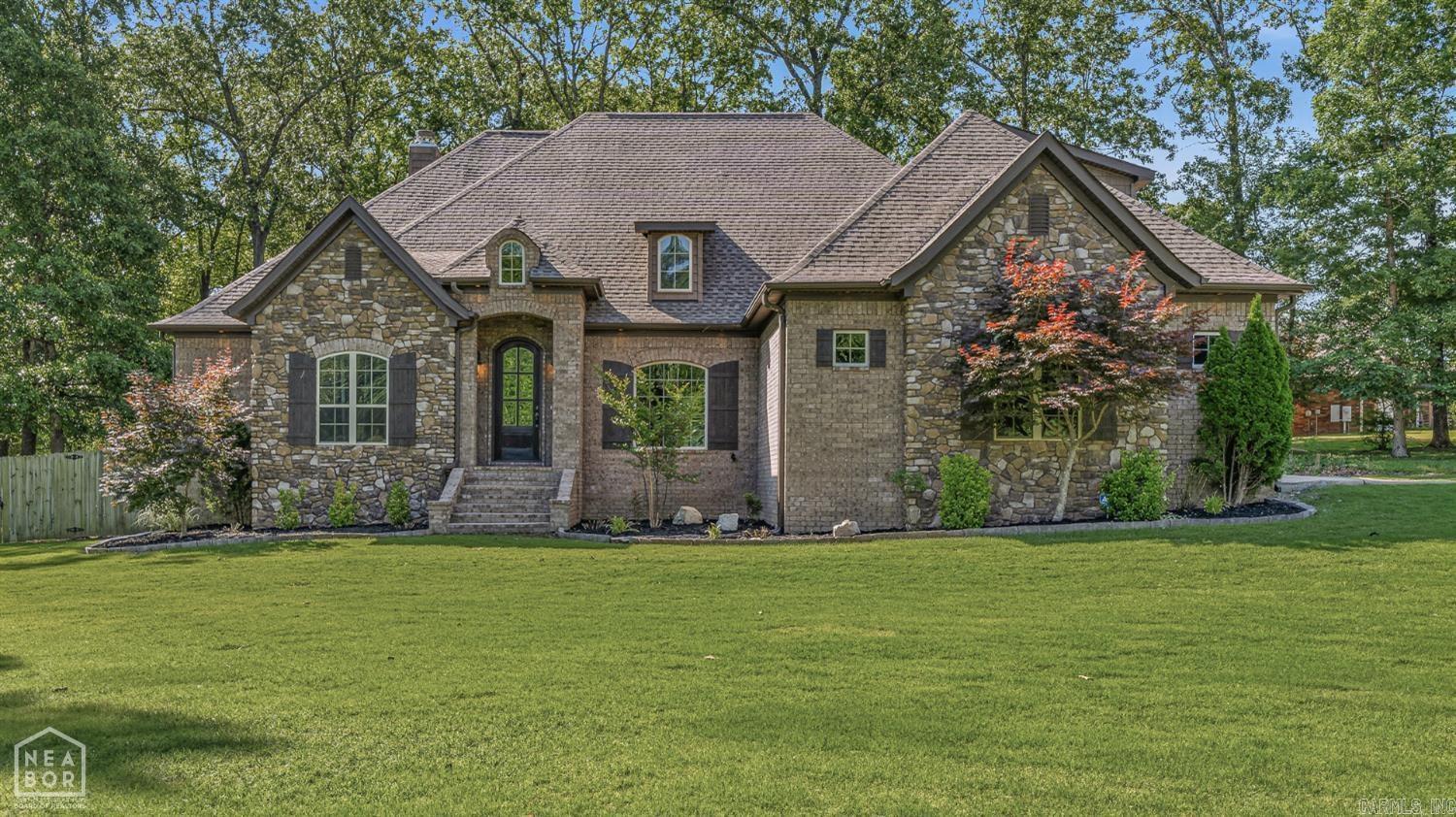 Tucked away on 1.6 beautifully landscaped and wooded acres, this stunning custom home offers the perfect blend of privacy, comfort, and timeless style. Built in 2014, the all-electric residence welcomes you with striking stone and brick exterior details and a warm, inviting presence from the moment you arrive. Inside, you'll find four spacious bedrooms and two and a half baths designed for both everyday living and entertaining. The living area features a cozy fireplace and custom built-ins, creating a perfect gathering space with character and charm. The thoughtfully designed floor plan includes a private upstairs bedroom and bonus room ideal for guests, a home office, or a playroom retreat. Outdoor living shines with both a covered patio and an additional deck, offering peaceful views of the surrounding wooded landscape and plenty of space to relax or host. A three-car garage provides ample storage, while a built-in safe room adds an extra layer of security and peace of mind.