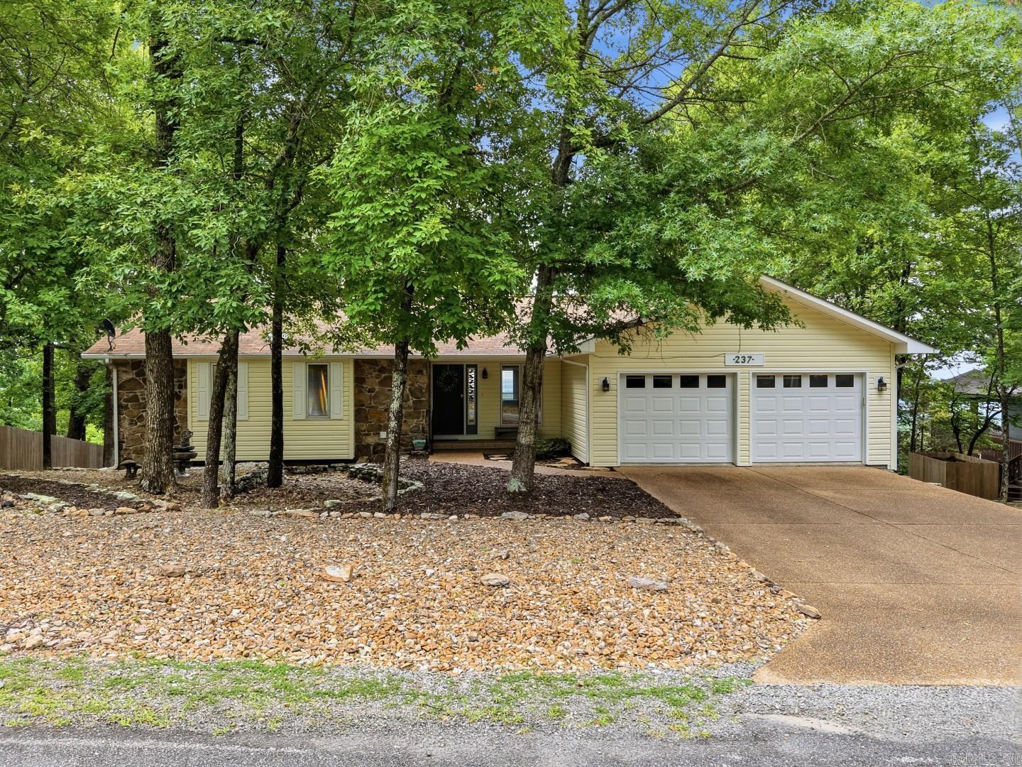 Wake up to breathtaking lake and mountain views with spectacular sunrises and full moon rises from this beautifully updated home. Designed for comfort and easy living, the spacious open-concept kitchen and family room create the perfect gathering space. The heated and cooled sunroom is the perfect place to enjoy your morning coffee or relax with a good book while overlooking the beautiful lake and mountain views. Fresh interior paint, new flooring, and updated lighting give the home a bright, modern feel. Oversized guest bedrooms offer generous closet space, while the lower-level den with a cozy wood-burning stove provides the ideal retreat. An additional bonus room is perfect for a bunkroom, hobby room, or extra storage. Enjoy outdoor living from the upper view deck, lower covered patio, or relaxing around the fire pit. With a low-maintenance yard and exterior, you'll have more time to enjoy the incredible views. Located in Fairfield Bay, you'll enjoy high-speed internet, two 18-hole golf courses, pickleball, hiking and biking trails, ATV/UTV trails, and Greers Ferry Lake with a full-service marina just minutes away.