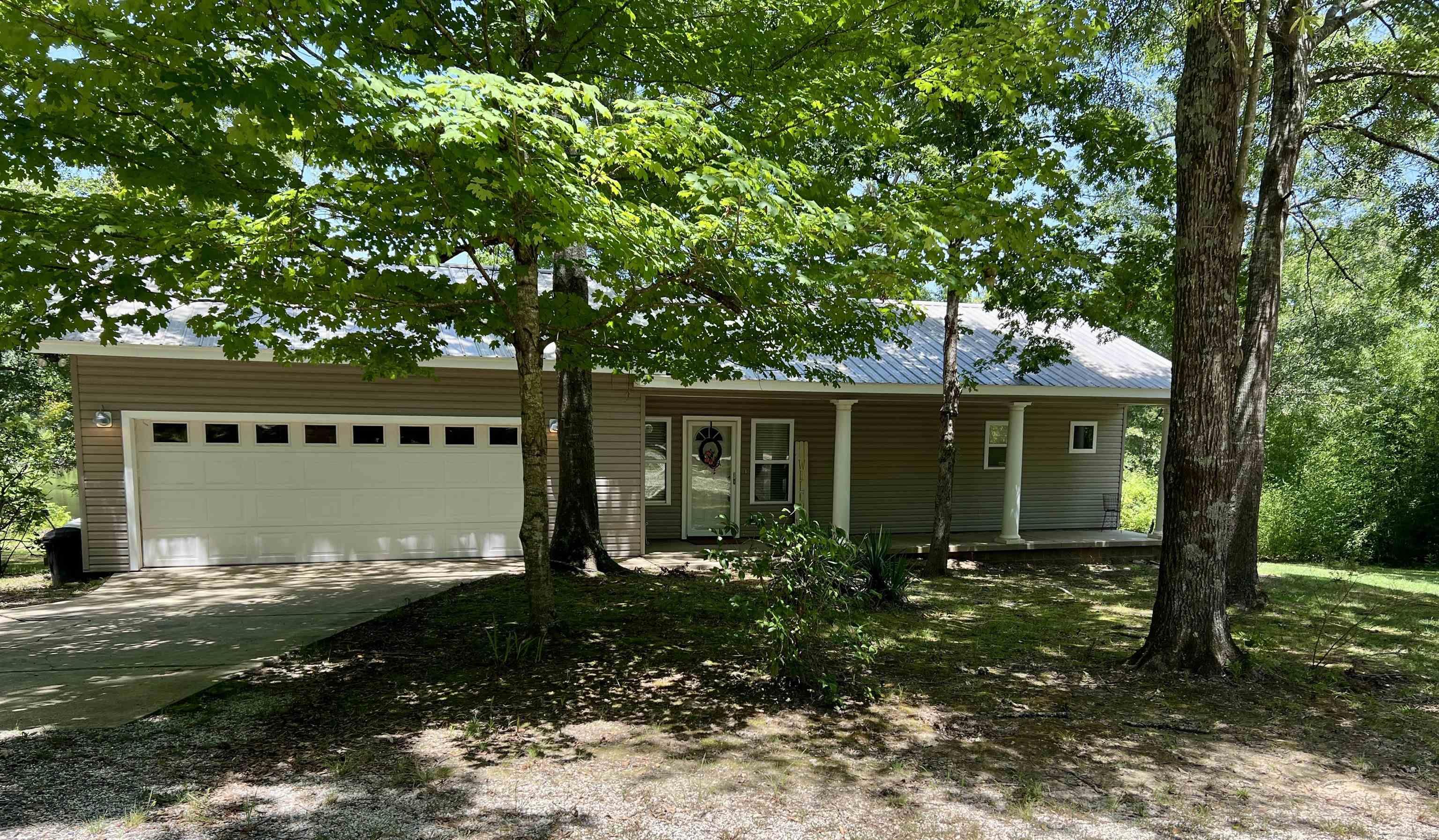 Nestled just minutes from both Henderson State University and Ouachita Baptist University, this 10-acre property offers a perfect blend of convenience and natural serenity. The well-kept 1-bedroom, 1-bathroom home sits on a gentle rise overlooking a beautiful 3-acre stocked pond—ideal for peaceful mornings or relaxing evenings on the back deck.  Designed with an open floor plan, the home feels spacious and inviting, with scenic views that bring the outdoors in. A portion of the garage has been thoughtfully converted into a large storage room, providing extra functionality without sacrificing space.