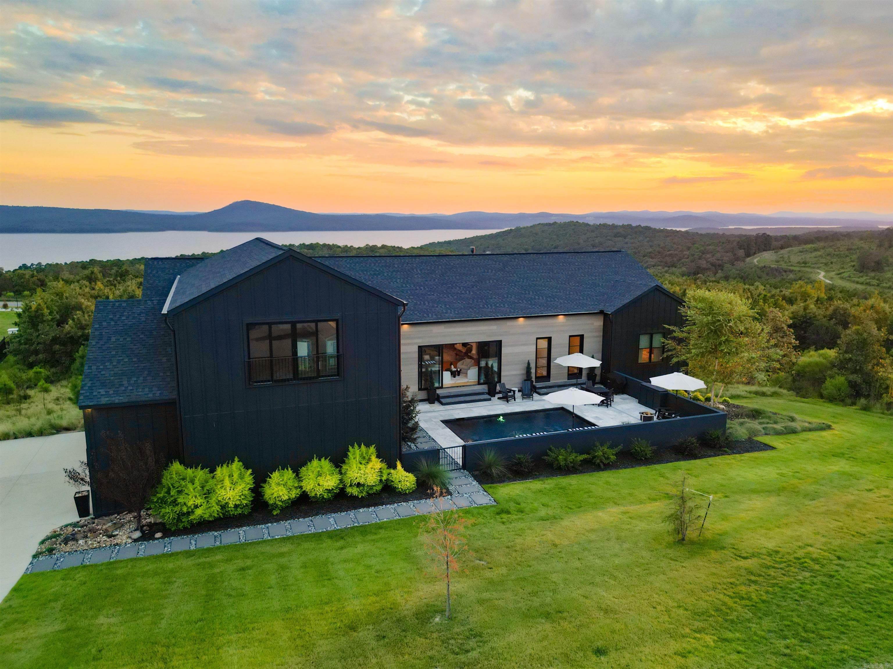 Stunning custom home by Dillon Homes, designed by Jill White Designs, situated on 2 acres in the private, gated Waterview Estates community with breathtaking views. This 4,457 SF residence offers 4 bedrooms, 4 full baths, and a powder room — every bedroom enjoys its own en-suite bath. Floor-to-ceiling Pella accordion doors seamlessly connect the living space to the pool and rear deck, creating an entertainer’s dream. White oak floors flow throughout the home, complemented by Fisher & Paykel appliances in the kitchen and a dedicated wine room and bar. The front-yard pool anchors the outdoor living, while a new $100K TimberTech deck (installed October 2024 by Sideco, Inc.) extends the entertaining space. Exterior finishes include James Hardie board-and-batten and MAC metal siding. Community amenities include tennis and basketball courts, soccer fields, walking trails, and scenic views of Lake Maumelle and Pinnacle Mountain — all just minutes from West Little Rock. Furniture negotiable.