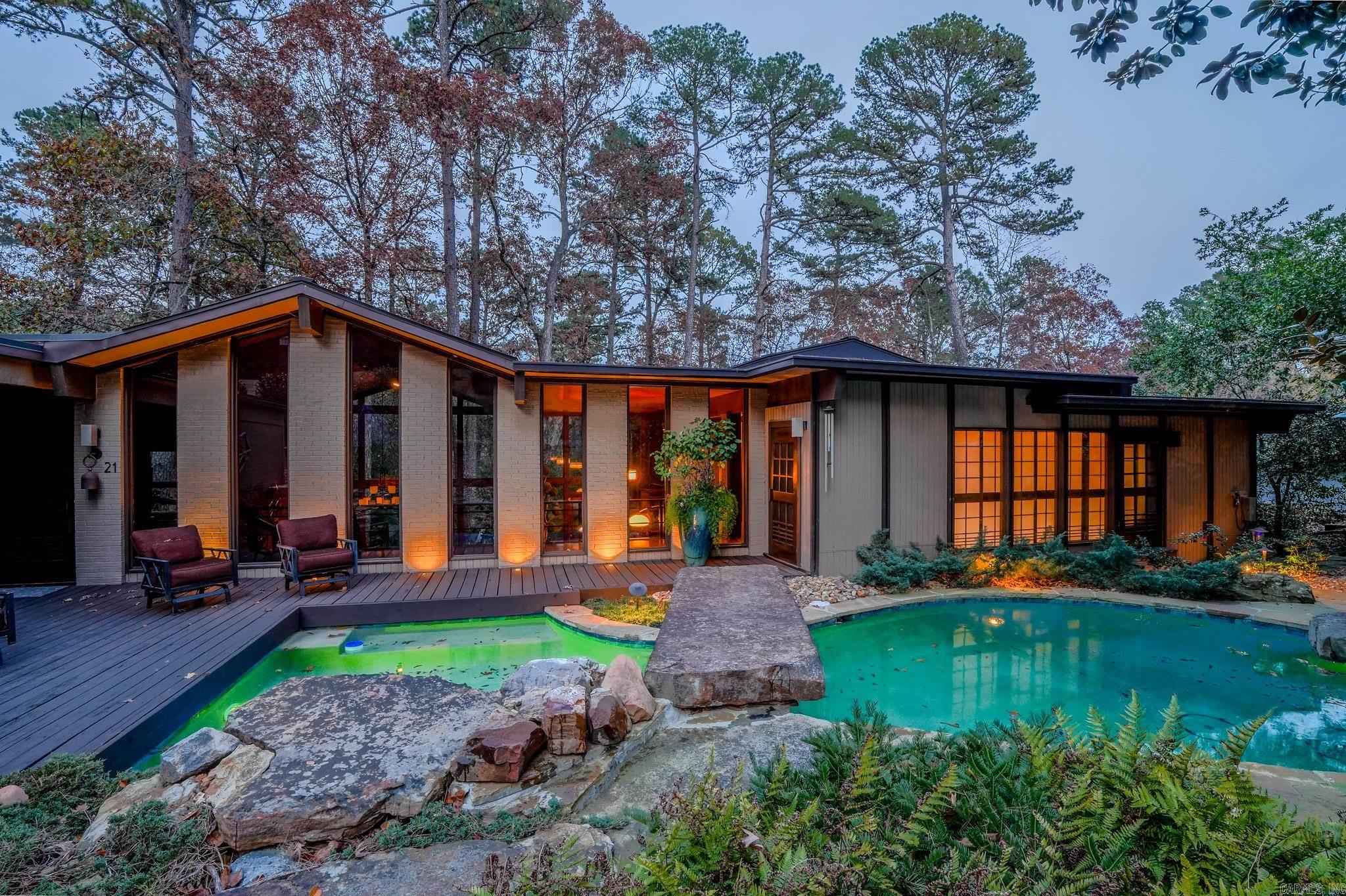 Step into a stunning mid-century modern showpiece designed by theatrical stage designer Robert Barnes and built by Don Holeman. This architecturally significant  home blends dramatic lines, rich materials, and an exceptional connection to nature. Nearly 6,000 sq ft of space , floor to ceiling glass, sunken living room with a double-sided fireplace, and slate floors give this 4-bed, 2.5 bath residence unforgettable presence. Set on a 1/2 acre that backs up to a 24 acre greenbelt in River Ridge, the home feels like a modern treehouse tucked into a private wooded ravine. The primary suite offers a fireplace, private deck, whirlpool tub, steam shower, in-floor hot tub, dry sauna and walk-in closet. Additional highlights include a spacious kitchen with high-end appliances,  copper vent hood, a utility room/butler's pantry, living room with bar, ample storage and a basement workshop.Outside, the renovated pool area creates a private oasis with stonework, landscaping, soothing waterfall, outdoor kitchen, and fire pit-perfect for unforgettable gatherings.This is a rare opportunity to own a meticulously maintained, MCM home designed for dramatic entertaining and tranquil everyday living.
