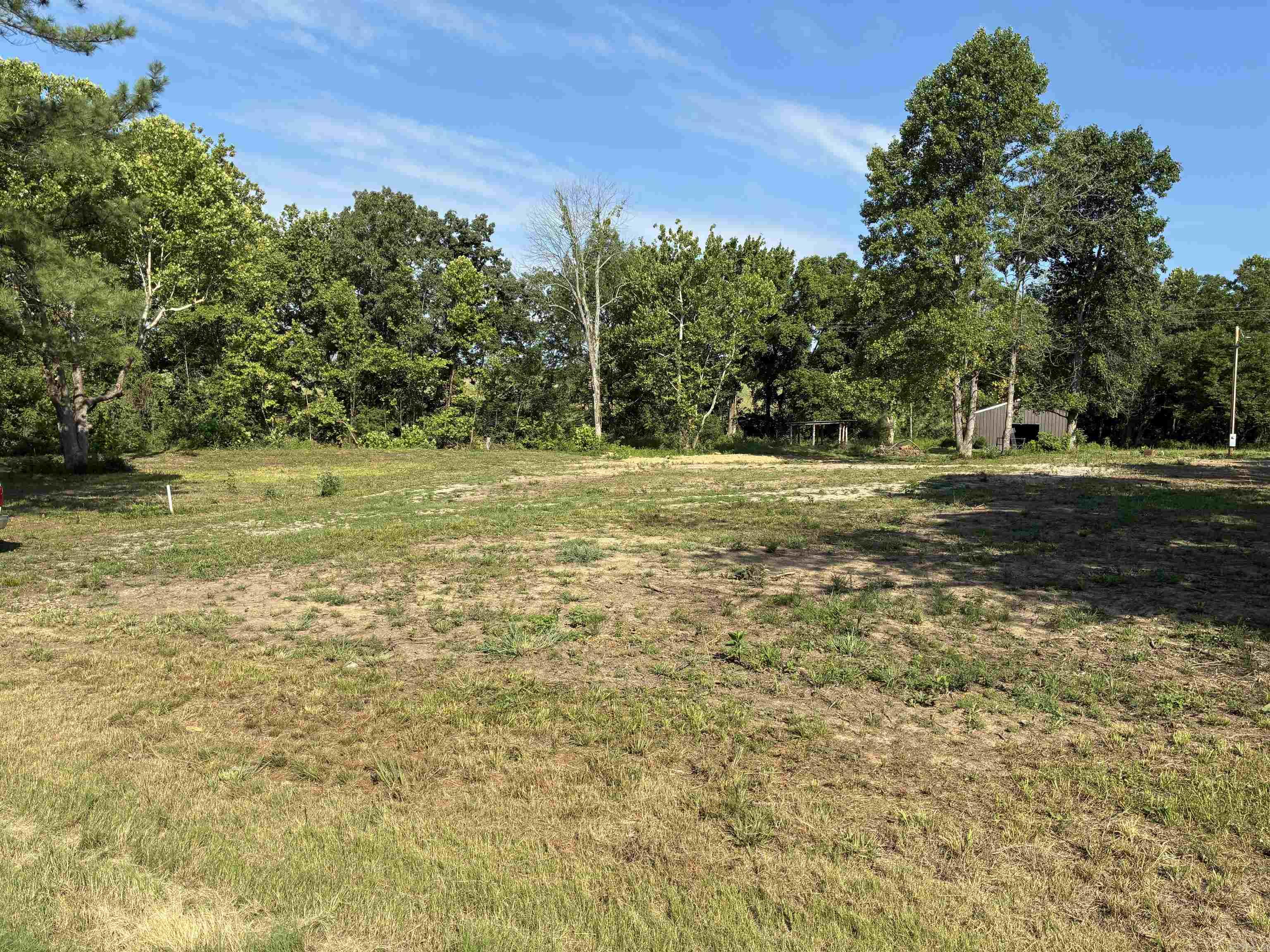 Bring your house plans! 4.25 acres M/L with electric and well already on site and cleared and ready to build. This land has road frontage on two sides, approximately 541 feet of state highway frontage and 416 feet of frontage along the county road.   In addition, there is a well and electric already to the center of the property. Also included are a small spring fed pond and a small creek that runs along the Southwest and West boundary of the property. This property has a good layout and several possible homesite locations and also offers plenty of privacy on this sized acreage.   A 30x40 shop is on the back of the property, perfect for dry storage or with a little work, could made into a a full functioning shop.