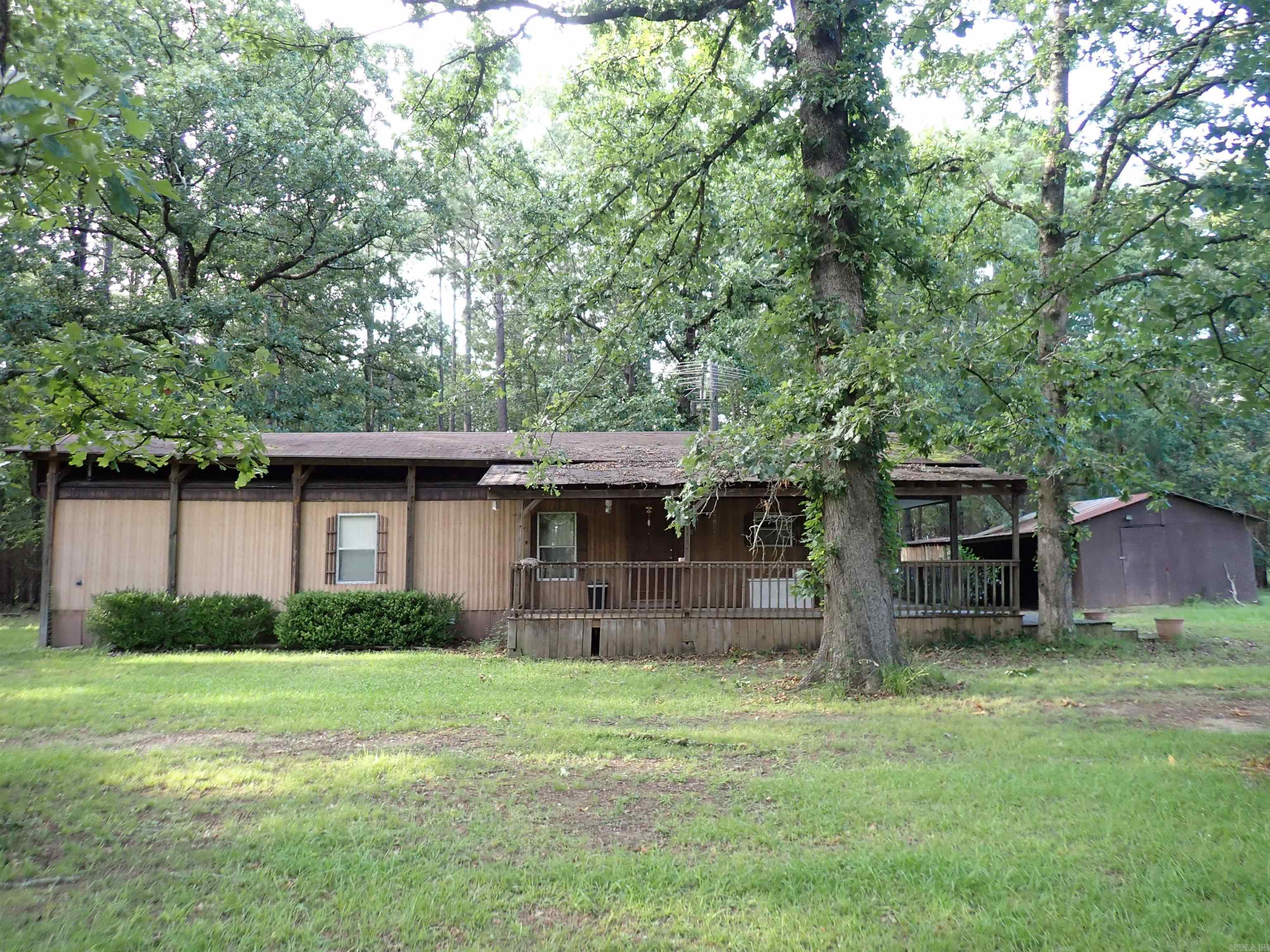 OFF HWY. 67 SOUTH, 13.98 ACRES, (professional Survey, 2018) & a single-wide, Manufactured home (NEW 1979) with frame addition, site-built (NEW 1993) & a second, site-built, shingle roof above the Manufactured home & a NICE 'L-shaped' FRONT PORCH/SIDE PORCH --- with METAL ROOF above the front porch.  Two or three bedrooms (depending on 'how' you wish to use the large, 'step-down' ADDITION which happens to have MEGA-hanging rod space [for clothing] and an additional exterior door).  So, you may either have a SECOND LIVING AREA -or- a THIRD-BR --- your choice!  There is 1 HALL BATHROOM (full).  The CH/A unit is a 'York' 4-ton system (electric).  Step-down addition happens to have a window A/C and a gas wall-mounted heater.  The CH/A unit is knowingly 'over-sized' for the 1,104 total SQUARE FOOTAGE of the residence.  The kitchen/dining combination & adjacent living room are spacious.  Other structures on this wooded, 13.98 ACRES include a detached SHOP (approx. 23' x 25') with adjacent/adjoining enclosed shed (approx. 16' x 24') -and- a detached STORAGE BLDG. (or smaller shop) with 2 adjacent/adjoining sheds.  Small, deep POND!  Amazing BUILDING SITE on North side of Subject Property!