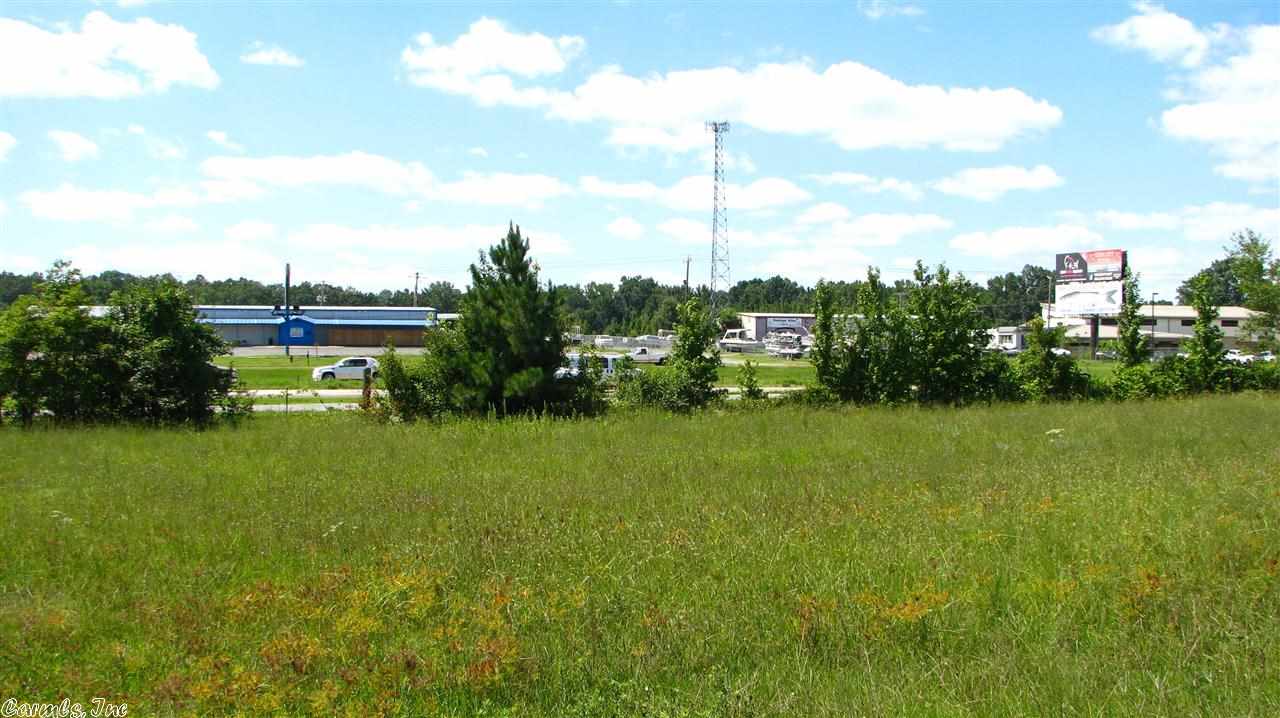 Great visibility from 67/167. 180' of frontage, level and mostly cleared. Partially fenced with 6' chain-link. 12'x32' building currently used as car sales office. In addition to this lot there are 7 more lots to choose from ranging from 3.8 - 6.5 acres. Parcels begin on southern boundary of Wild Hog Liquor Store and continue to northern boundary of former Busy Bee location. City water, commercial zoning in place.  Some lots include metal buildings pictured. Call office for more details.