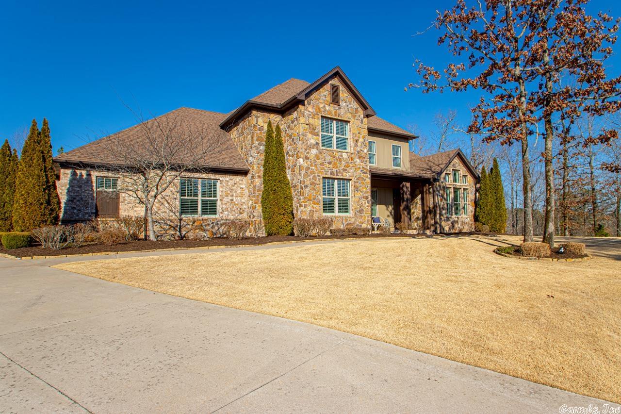 Private retreat that showcases extraordinary indoor/outdoor living!  A wall of windows greets you at the front door highlighting the beautiful saltwater pool with waterfalls, bubblers, & rock baja shelf privately nestled in the trees with protected green space behind backyard.  Covered pool cabana with TV over gas fireplace, outdoor kitchen and shower, wood covered back porch with TV & wall encased gas fireplace.  Long driveway leads to extra parking/play area and side loading 4 car garage that is oversized.  Open concept living / dining / kitchen (gas range, large granite island, subzero fridge, ice maker, microwave, convection oven), formal dining (sitting area), office, 3 ensuite bedrooms (primary separate w/coiffured ceiling, heated bathroom floor), laundry, 2 walk-in pantries, mudroom, guest/pool bath all on main floor.  Up - large bonus/game room, large bedroom, full bath, exercise/craft room (could be 5th or guest bed).  Tons of storage & generator (2022).  Nature trails, ponds, tennis, playground, pool in family friendly neighborhood.  Agents see remarks.