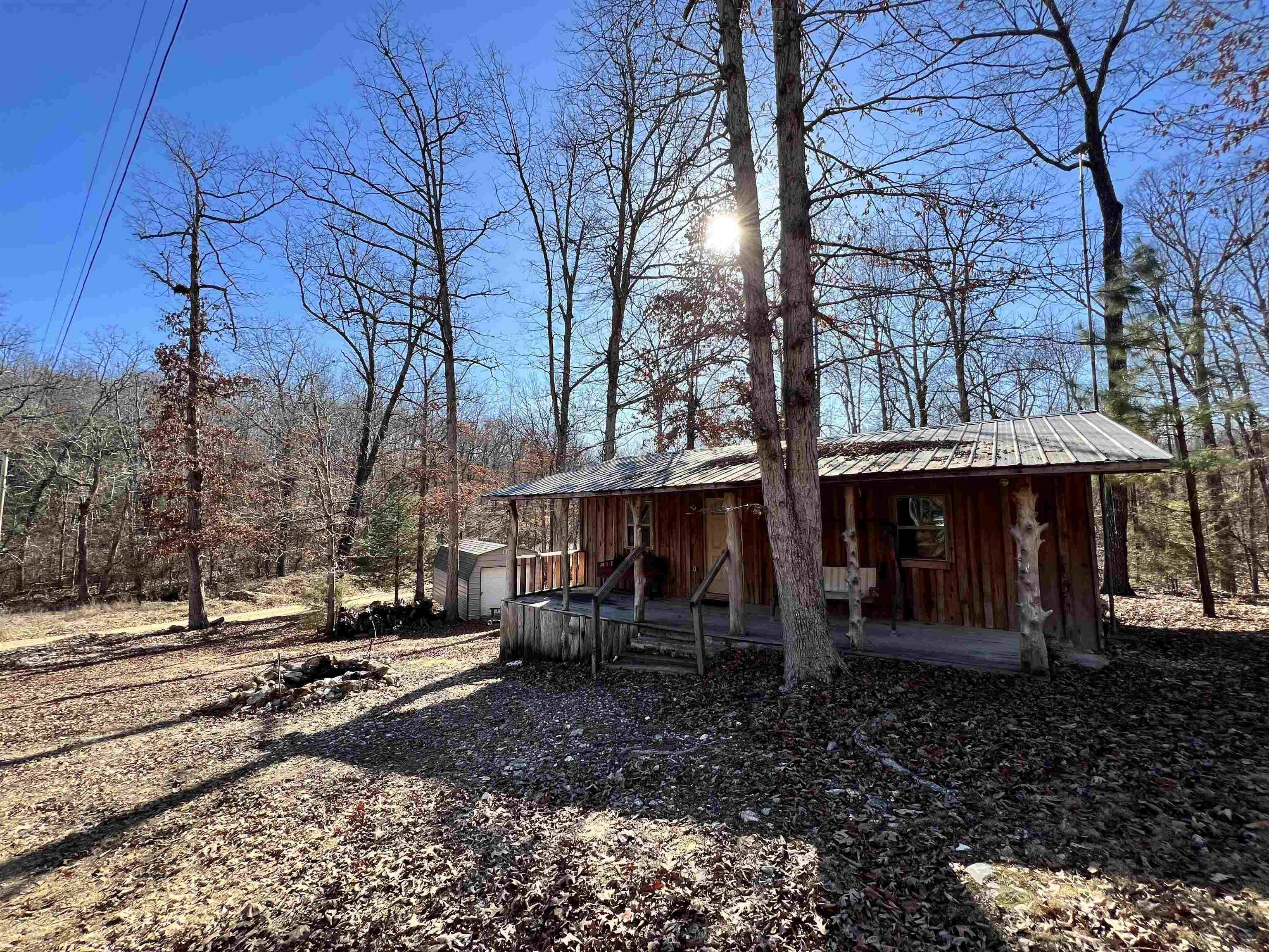 Nestled amidst serene woods, this charming rustic cabin offers a cozy retreat. Recently remodeled, this 704 sq. ft. gem boasts a single bedroom along with a bonus room used as a 2nd bedroom, perfect for flexible use. The peaceful surroundings ensure privacy with no immediate neighbors, providing an ideal escape. Its proximity to lakes and the beautiful Spring River makes it an ideal getaway spot. Inside, a fully-equipped kitchen welcomes you, featuring modern amenities such as an electric stove, dishwasher, and refrigerator. Additionally, a storage building offers practical space for all your needs. This cabin embodies tranquility and comfort, making it an irresistible destination for nature lovers seeking a serene haven.