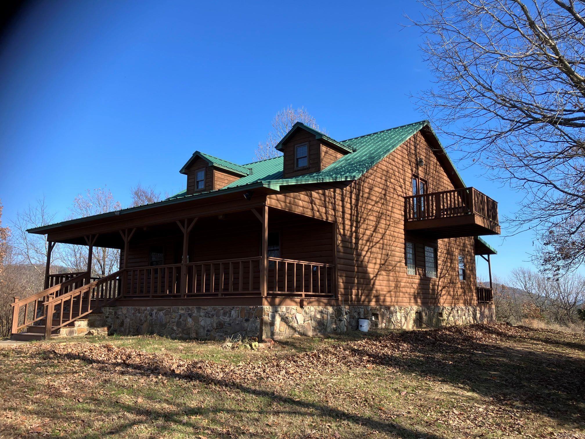 Own your own hilltop! Beautiful log sided cabin perched at 1292' elevation. Vaulted great-room with laminate floors and floor to ceiling propane stone fireplace.  Open kitchen with island. Primary Bedroom on main level along with a second bedroom also on the main level (both with private bathrooms).  Upper level has another Primary bedroom, bathroom, balcony and a loft w/ large storage walk-in closet. Front and back covered decks with views of the surrounding hills. Ample wildlife in the area. House is very close to the Forest Service Land where you can ride your ATV's all the way to the Wolf Pen Gap. So much privacy, words can't describe, it needs to be felt as to what an amazing location this is. A home can always be updated to match your own taste, but finding a solid well built Cabin in this location can't be easily replicated at this price. Also listed with 16 acres/spring fed pond for 425k. See approx map in photos of the 2 acres and approx 16 acres. Plenty of room near the Cabin to build a large shop/garage. RV Hookups on both sides of the Cabin. Taxes are TBD as this is being split out of a much larger parcel.