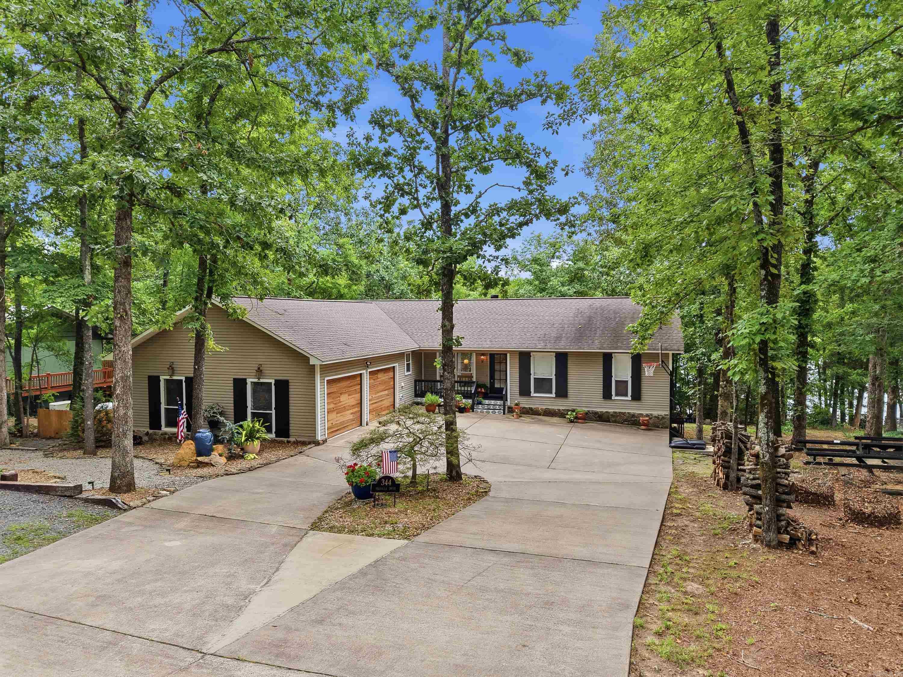 LAKE FRONT RETREAT in the exclusive Mystic Isle subdivision! Offering over 4,000 sqft, this beautifully updated home features 3 bedrooms and 3.5 baths, with each bedroom designed as a private suite overlooking the lake. Two spacious living areas on separate levels provide room for family and guests, while expansive decks and two newly added porches stretch across the back of the home, capturing views of Greers Ferry Lake. Enjoy a truly easy walk to the lake right out your back door! The kitchen has been beautifully updated with a combination of gorgeous butcher block and quartz countertops. Luxury vinyl flooring, fresh paint, updated lighting, and thoughtful improvements throughout make this home move-in ready. Other upgrades include four sliding doors, a beautiful front door, two HVAC units, a hot water heater, garage doors, shutters, parking pads, and a storage shed. Outside, extensive landscaping enhancements include all new rock pathways and rock riverbeds on both sides, creating a low-maintenance and inviting setting. You’ll love the convenience to town while enjoying the tranquility of this area. Homes like this don't come along often. Come see why life is better at the LAKE!