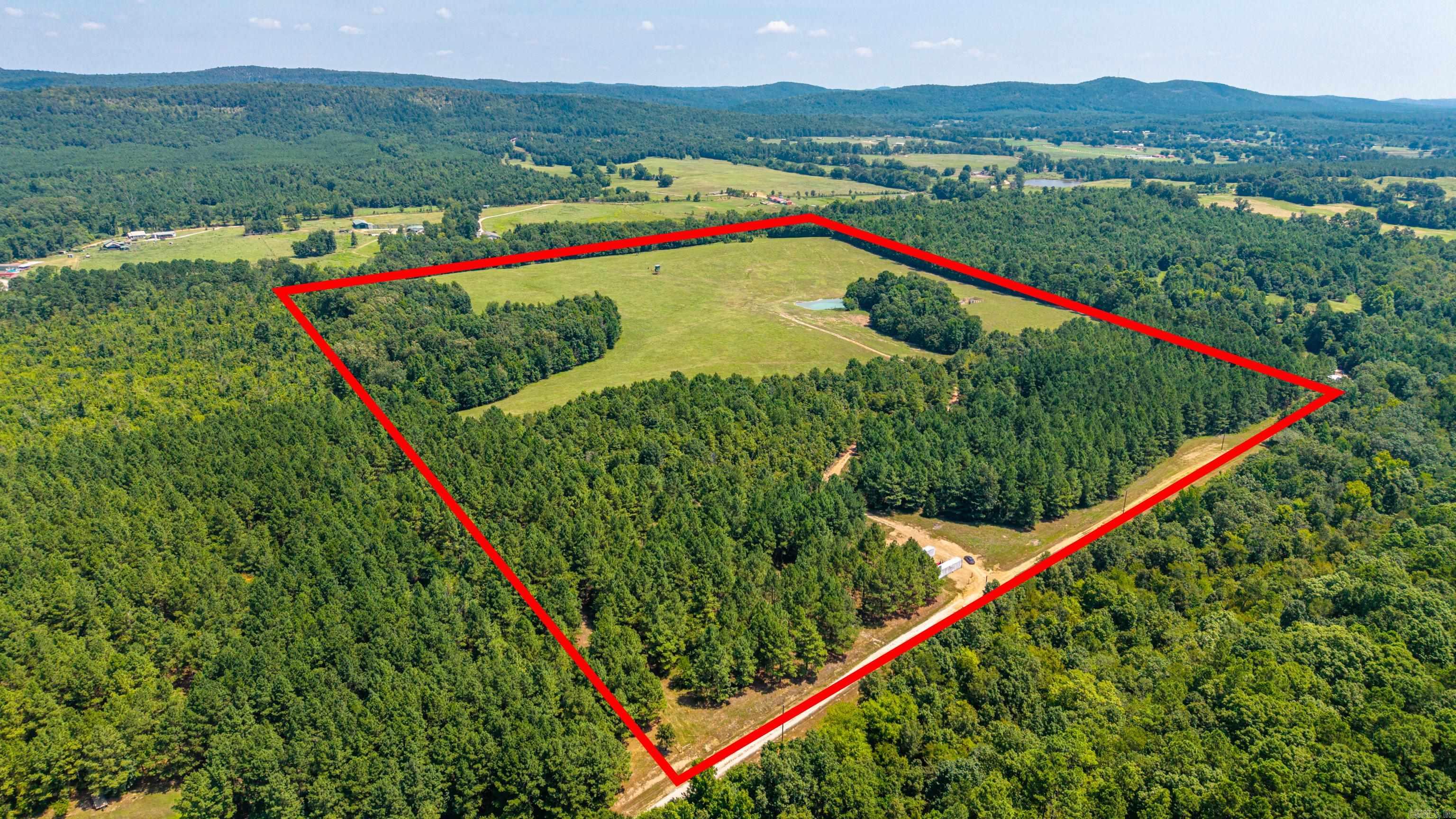 Welcome to Ouachita Valley Farm! This turn-key 56-acre farm is ready for livestock, recreation, or your dream home. Just 2 minutes from Bismarck Schools, this improved property features lush pasture, ponds, natural springs throughout, and well-maintained fencing. The front 16 acres have new fence posts already in place, with the remaining fencing to be completed prior to closing. The impressive 24ft-wide entrance is designed to accommodate large farm equipment, including hay trailers, and can be gated. A sturdy corral with a working chute makes handling cattle a breeze, while existing electric service, a well, and nearby city water provide the infrastructure to get started immediately. The property has been professionally mulched, seeded, and completely cleaned of debris, creating a productive setting for farmers, hunters, or anyone seeking a private homesite. Enjoy breathtaking views of Jack Mountain from the perfect future building site, and take advantage of the potential for a hunting lease as an added investment opportunity. 2 freezer trailers convey. Whether you're expanding your operation or building your forever home, Ouachita Valley Farm is ready for it's next chapter.