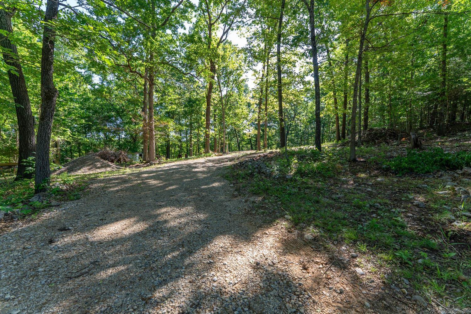 Land For Sale Near White River   Nearly 7 acres in Marion County, Arkansas, less than a mile from access to the famous White River. This private and peaceful property offers an ideal setup for camping, recreation, investment, or building your Ozarks getaway. Conveniently located near Highway 62 and only a quarter mile down a well-maintained gravel road, the property is just minutes from Cotter, Big Spring Park, and only five minutes from Walmart. Improvements already onsite include city water, septic, and 200 amp electric service. The RV pad features sewer, water, and 110/30/50 amp hookups, perfect for RVs or campers. Additional features include two frost-free hydrants, a brand-new driveway, trails throughout the property, fencing on two sides, and a large cleared private area with a prepared pad ready for your future home, cabin, or shop.