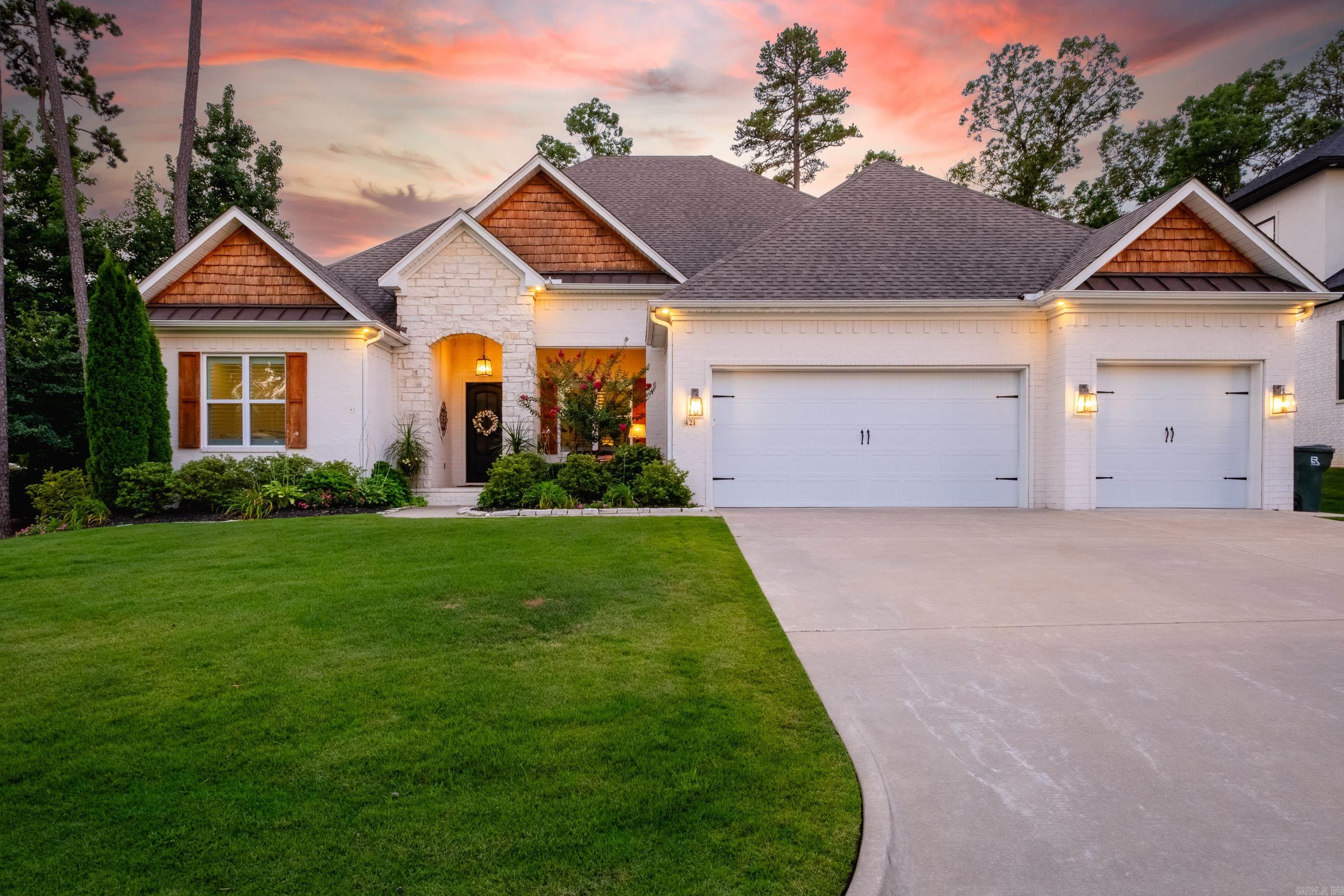 Exceptional one-level home truly has it all! Featuring 4 bedrooms, 3 bathrooms, a dedicated office with a closet that could easily serve as a fifth bedroom. The transitional style blends timeless elegance with modern comfort, making it easy for any buyer to envision their personal style here.  The floor plan includes both a formal dining room and a breakfast nook, providing options for everyday living and entertaining. The beautiful kitchen opens to the main living spaces, while the three-car garage offers ample storage and convenience.  Step outside and discover a backyard oasis. The screened porch features a fireplace and retractable screens, allowing year-round enjoyment and added warmth during cooler months. Beyond the porch, an incredible pool and hot tub are surrounded by a travertine deck that stays cool underfoot even in the Arkansas summer heat. Extensive landscaping, lighting, privacy fencing, and additional plantings create a resort-like setting that feels secluded and serene. The exterior showcases a striking combination of white brick, stone, and wood accents, delivering impressive curb appeal!