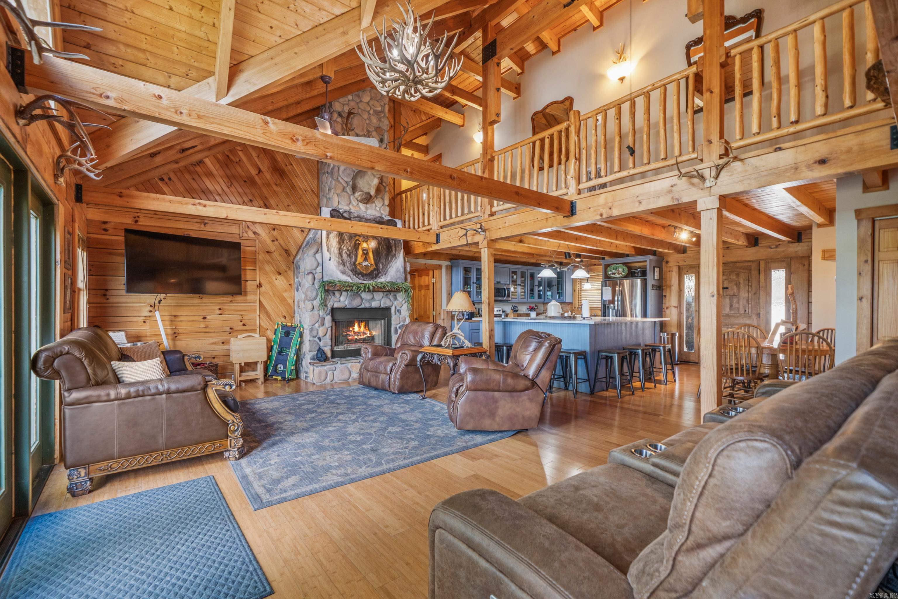 One of a kind lakefront log cabin! This 5 bed, 5 bath home offers a rare combination of space, character, and lakefront living with 82 feet of lake frontage on Lake Hamilton. Every bedroom has its own en suite, providing comfort and privacy for family or guests. The main level features. two primary suites, while upstairs offers tow additional bedrooms with private baths. The lower level includes a second living area with a pool table, plus another bedroom and bath--perfect for entertaining or multi-family use.   Vaulted ceilings, spacious rooms, and warm log-cabin charm create a cozy yet grand atmosphere. Step out onto the back porch to take in gorgeous lake views. Selling fully furnished, this home is currently operating as a licensed short-term rental, with the license transferable to the new owner. Ideal as a primary residence, vacation home, or income producing property.