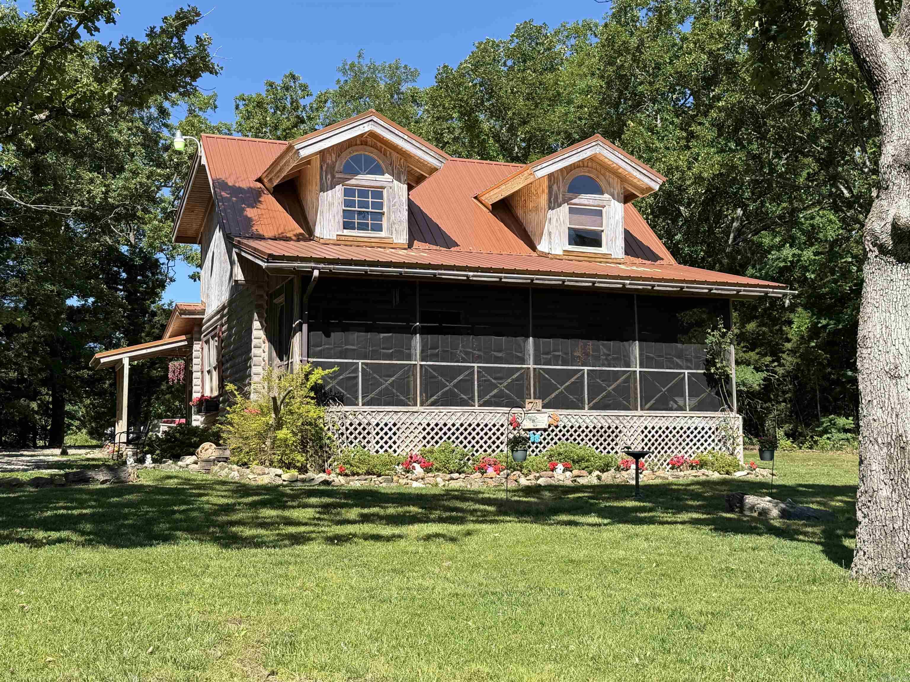 Discover the perfect blend of rustic charm and modern comfort in this beautifully crafted log home, nestled on 20 private acres in the rolling hills of Sharp County. Hand-hewn log construction, gleaming bamboo hardwood floors, and a fully updated kitchen with newer stainless steel appliances create a warm, inviting interior. The main level features two spacious bedrooms and two full bathrooms with attractive tile flooring. A large loft with its own closet offers flexible use as a third bedroom, office, or creative space. The property is ideal for hobby farming or homesteading, with fencing, fruit trees, and multiple outbuildings ready for animals, equipment, or workshop needs. A new septic system, French drains, storm shelter and a striking bronze metal roof provide long-term peace of mind. Enjoy a mix of wooded acreage—perfect for hunting, hiking, and privacy—and open pastureland ready for livestock or expansion. This is true Ozark living: quiet, scenic, and full ofpossibility.