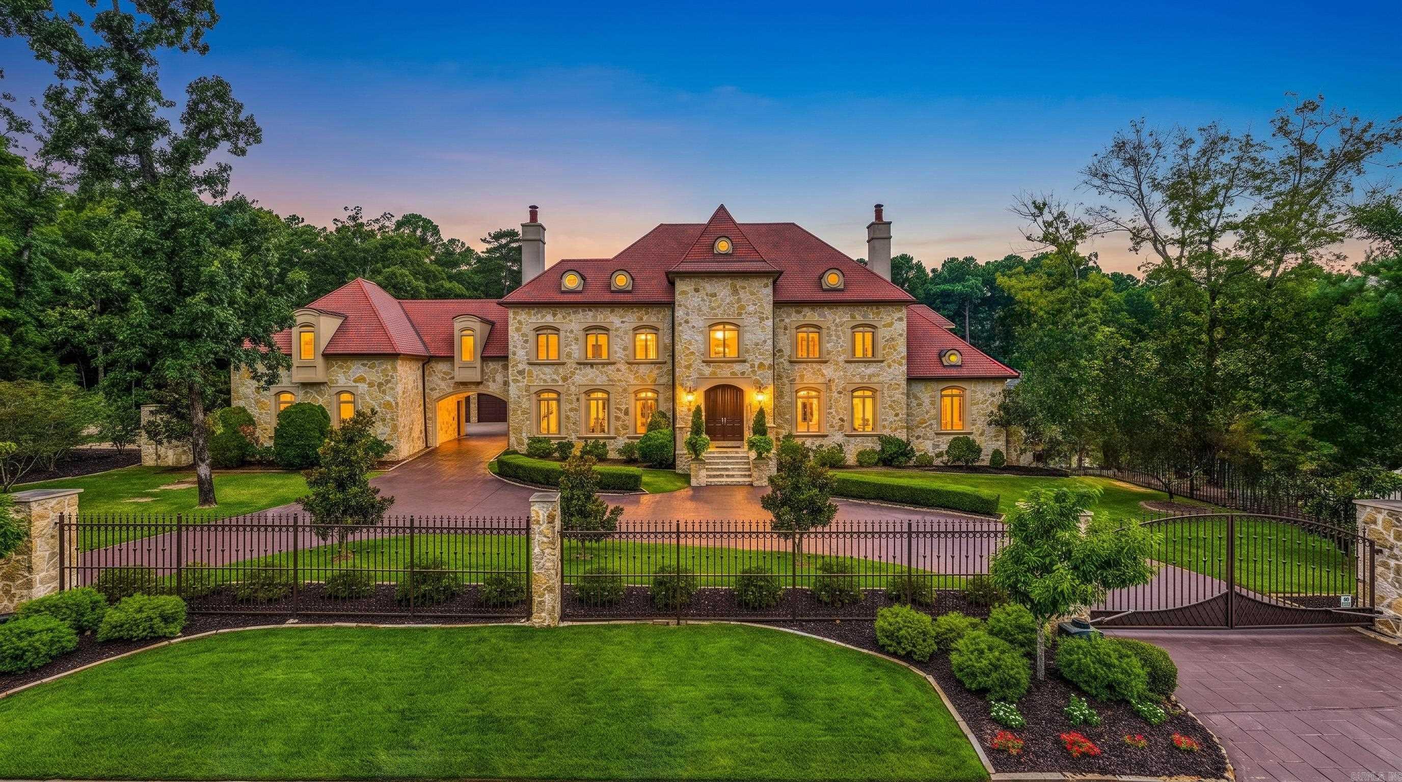 Inspired by the iconic Neiman Marcus Holiday House, this extraordinary custom estate blends timeless architecture with exceptional craftsmanship in the gated community of Valley Falls Estates. Designed for both grand entertaining and comfortable everyday living, this remarkable home offers approximately 9,742 square feet with 6 bedroom suites, each with a private bath and walk in closet. The luxurious main level primary retreat features two custom closets and a beautifully appointed spa inspired bath. The chef’s kitchen is equipped with Sub-Zero, Viking and Bosch appliances, an oversized island, prep sink, generous pantry and abundant workspace. An elevator serves all levels, while extensive floored attic storage adds incredible functionality. Resort style outdoor living includes a gunite pool and spa, basketball/tennis court, covered patio with fireplace, outdoor kitchen, and beautifully redesigned landscaping. Additional highlights include a theater with tiered seating, game room, fitness room, six fireplaces, whole house generator, tile roof, five car garage and motorized gates. A truly exceptional offering in one of Little Rock's most desirable neighborhoods. Come see!