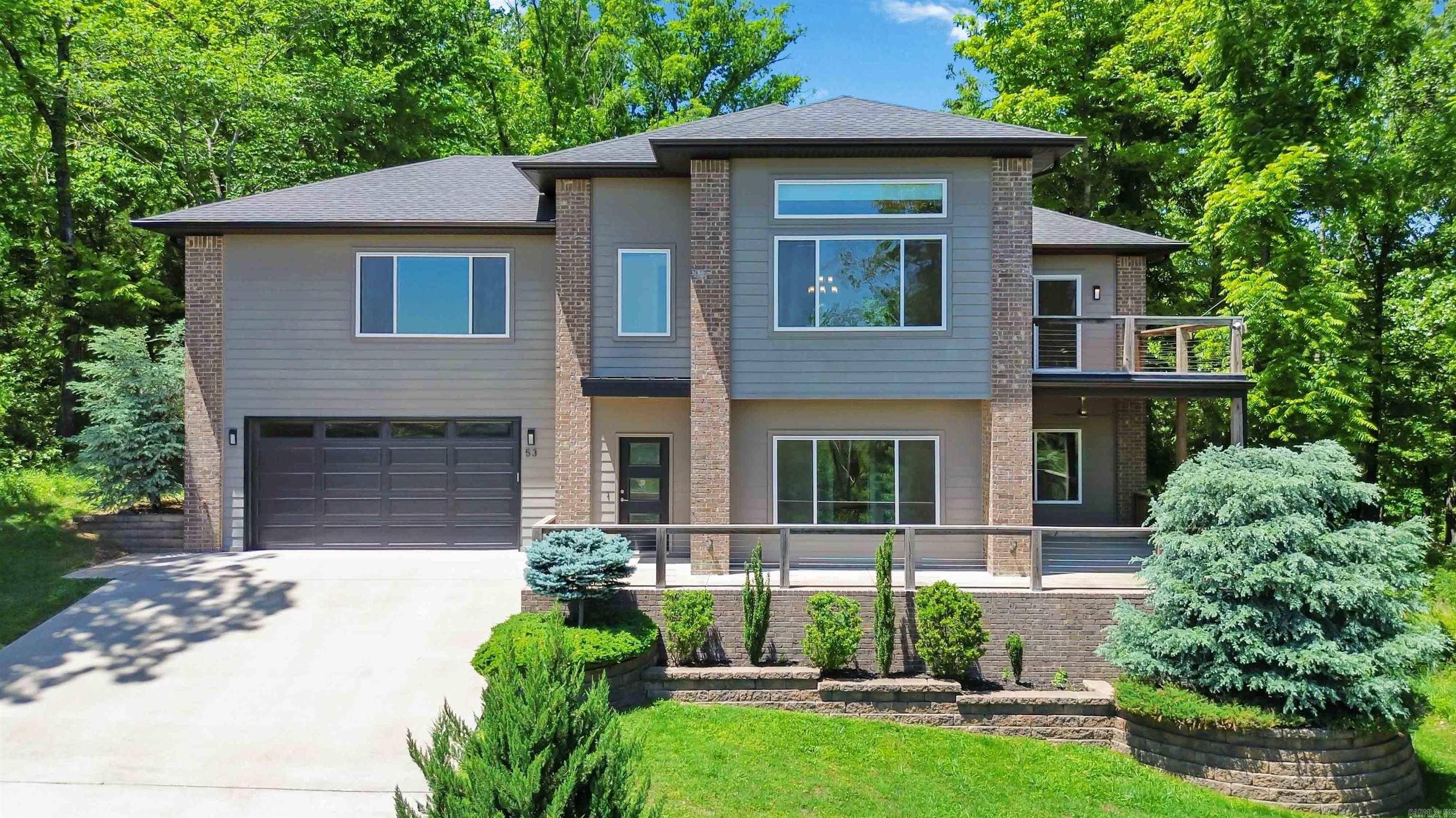 This stunning EAST Facing, LAKE-VIEW home offers a unique and flexible layout just 4 minutes from Lake Windsor and 7 minutes from the new Ozark Trail lift. The main level features a formal living room, 2 guest bedrooms, full bath, new carpet with elite foam padding. Upstairs features the kitchen, dining area, primary suite, and a stunning family room with, propane fireplace, custom railroad wood accent wall, ambient lighting, and year-round lake views. The top window in the upstairs family room features a motorized shade.The kitchen has a waterfall granite island with railroad wood accents, soft-close cabinets, slide-out pantry drawers and under-sink filtration system. Laundry room on both levels.Primary bath includes a whirlpool tub, tiled shower, and double vanity. Additional features: dual-zone HVAC controls, new AC (2023), screened-in porch (2020), front and back decks,Tesla charger, whole-house surge protector, gutter guards, smart recessed lighting, built-in garage storage.