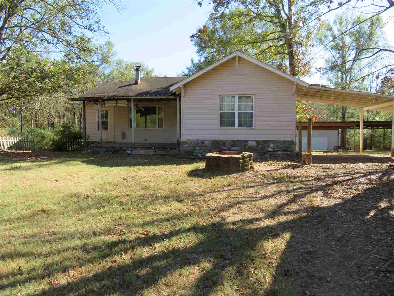 Cute country dumpling, nice neighborhood. Large older home with great potential. Den or bonus room, new laminate, original hardwood, new countertop. Central h/a, wood heater on native stone, ceiling fans, built ins, new windows, laundry, carport, large workshop/garage for two cars, storage building, four stall shed with electricity for boat, tractor, or rv. Deck, patio, three acres with privacy, partially fenced, garden spot, great yard for children and pets, city water, septic. LHSD. Call today to see!