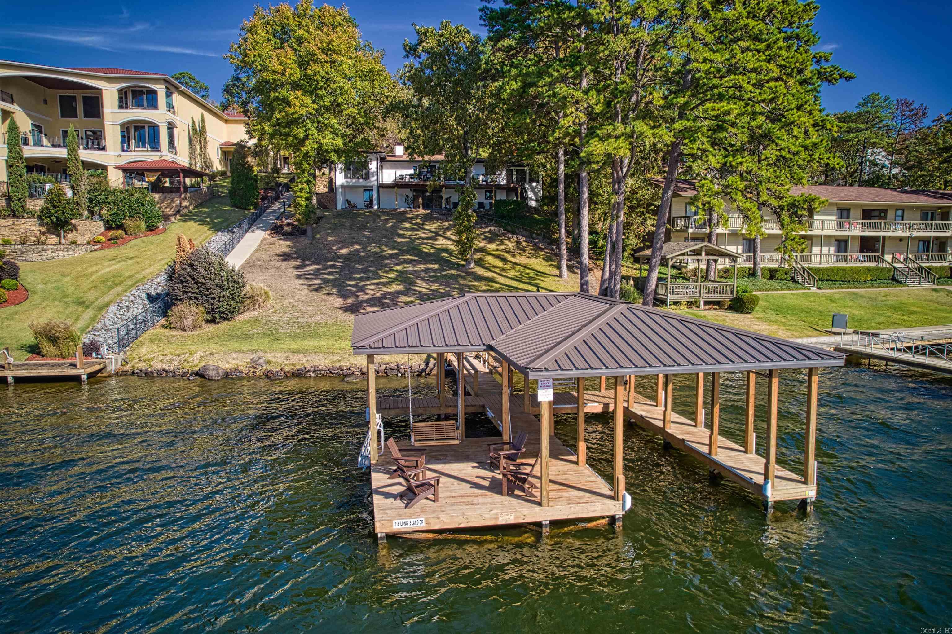 Discover 316 Long Island Dr., a fully furnished, remodeled Lake Hamilton home with 4 bedrooms, 3 baths, and a private dock. It is currently a successful vacation rental or could be your forever home, this stunning property showcases modern updates throughout. Enjoy the open living areas, a gourmet kitchen, and a serene master suite. With direct access to Lake Hamilton, this home invites boating adventures and tranquil lakeside living. Don't miss the opportunity to own this exceptional property that offers endless possibilities for vacationers and homeowners alike. The Large shop offers endless possibilities as well.  New HVAC in 2020, New roof coming as we speak.  Full security system with camaras, Tankless HW, Back up generator as well.  The list goes on.