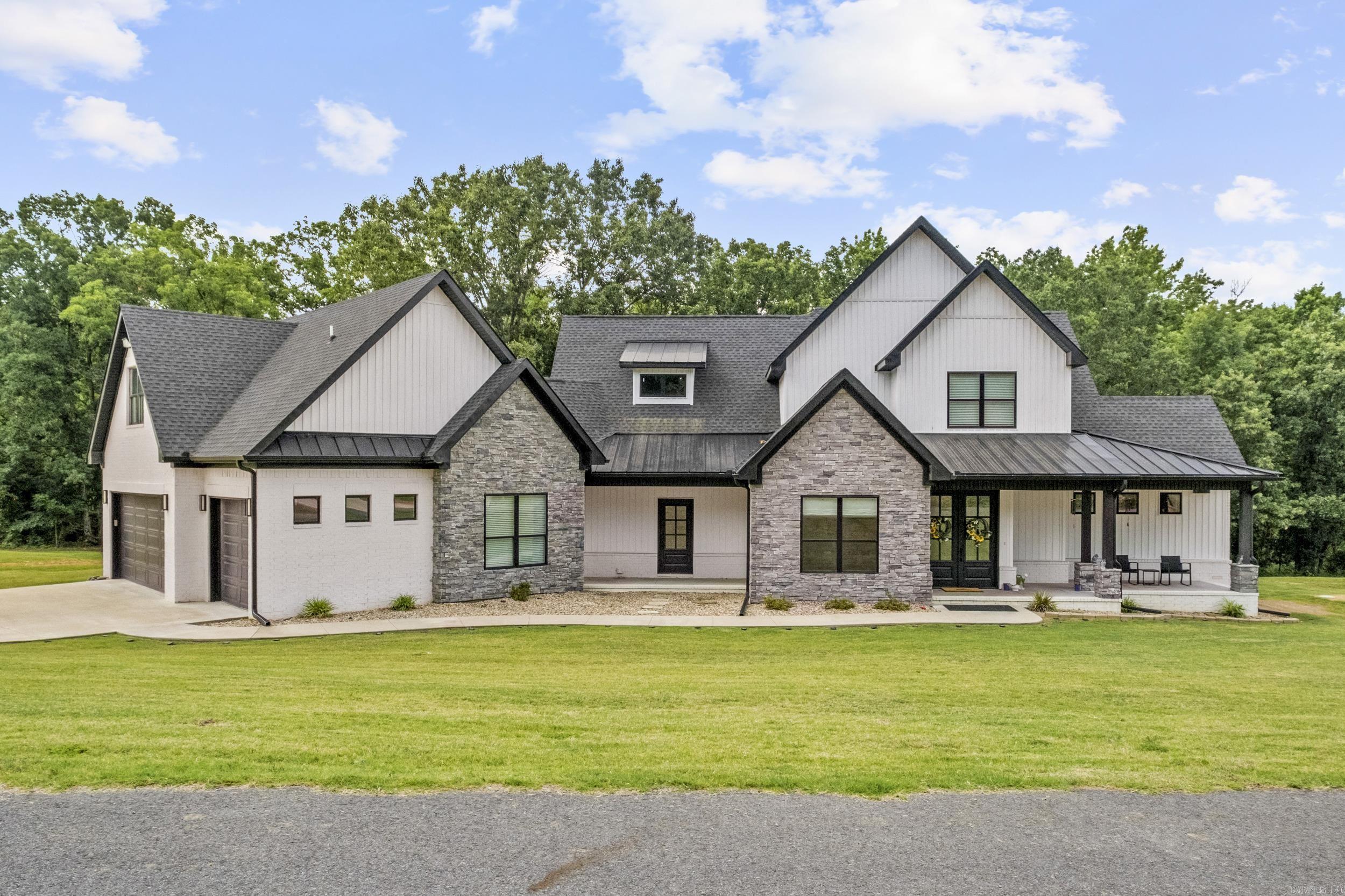 This stunning home checks all the boxes! It sits on a beautiful 2.64 acre lot in a gated subdivision with a fantastic view of the community fishing lake next door. The spacious living room features a vaulted ceiling with wood beams, stone accented gas log fireplace with a view of the lake. The gourmet kitchen is open to the living room. It has a huge island with a breakfast bar to seat the whole family plus a gas cooktop, double wall ovens, wall microwave, and a huge pantry with butcher block tops and a drink fridge. Kitchen fridge will stay. Elegant master suite downstairs with all the bells and whistles! Two laundry areas, one up and one down. The stackable laundry set will stay. Huge back covered back porch with wood ceiling. Bedrooms galore with 4 full bathrooms, really could be considered a 5 bedroom home. 3 car garage that has a 278 SF room that was built for dogs, currently used for storage. Great feature for dog owners! Built for energy efficiency with radiant roof barrier decking, spray foam insulation and tankless water heater. No carpet, LVP in living areas with ceramic tile in wet areas.  Come and see this fantastic home for yourself!