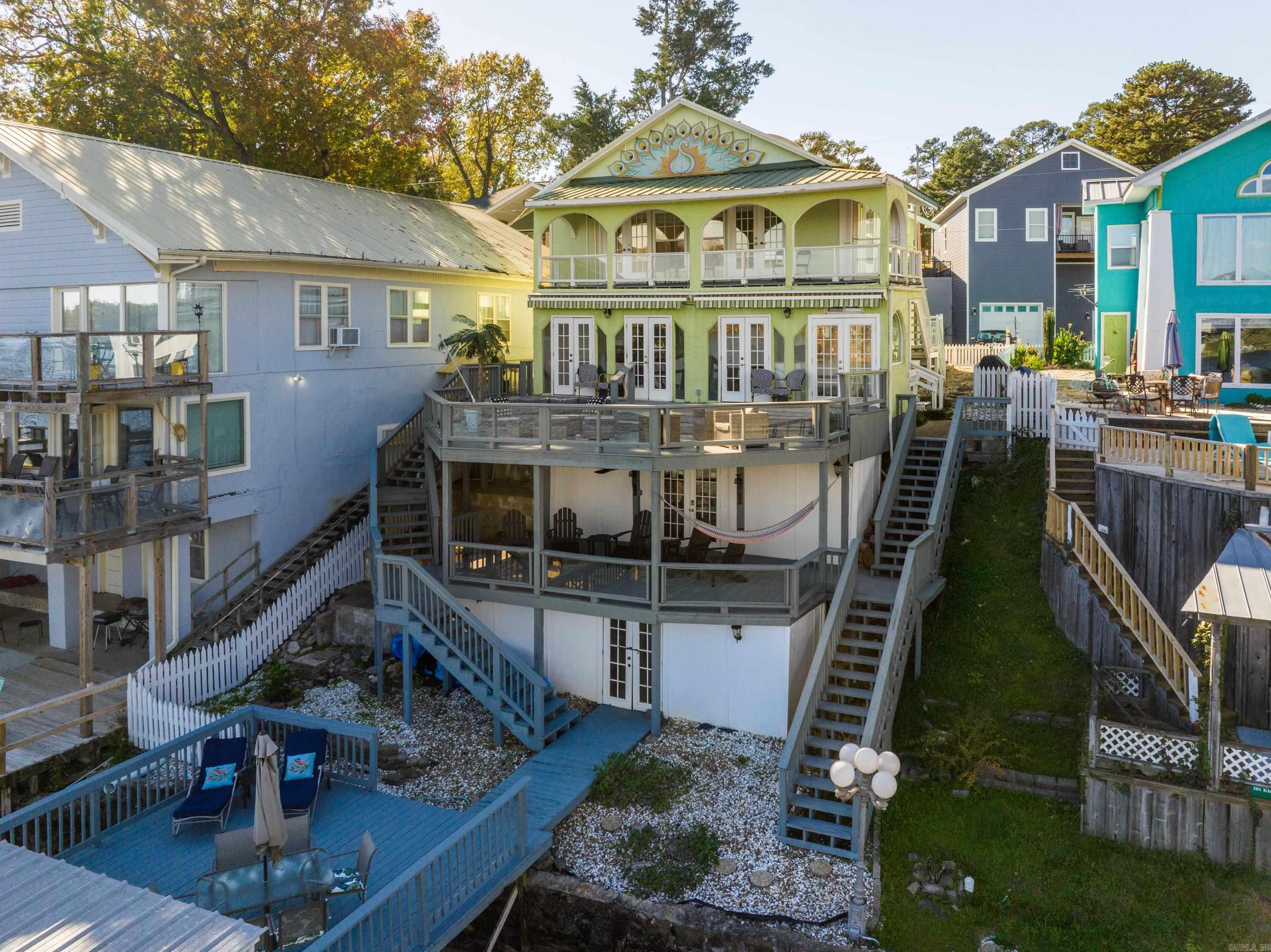 Location, location, location!!! This 3bd/3ba historic main channel lake home is available for nightly rentals or personal enjoyment.  Use it for personal fun or rent it out for additional income. Easy access to town but just a stones throw from the city limits make it the ideal vacation rental property.  No extra permits required!  Enjoy one of the 4 decks overlooking Lake Hamilton and bask in the views.  The covered boat dock has water access even during the winter. Kitchen has new appliances and granite countertops. Upstairs has original hardwood floors refinished to their original glory. There is an extra kitchen outdoors for all your entertaining needs. Each deck is appointed with outdoor furniture for maximum enjoyment. Carport plus a dedicated parking spot is assigned to this house, and the neighborhood has a pool for an extra perk.