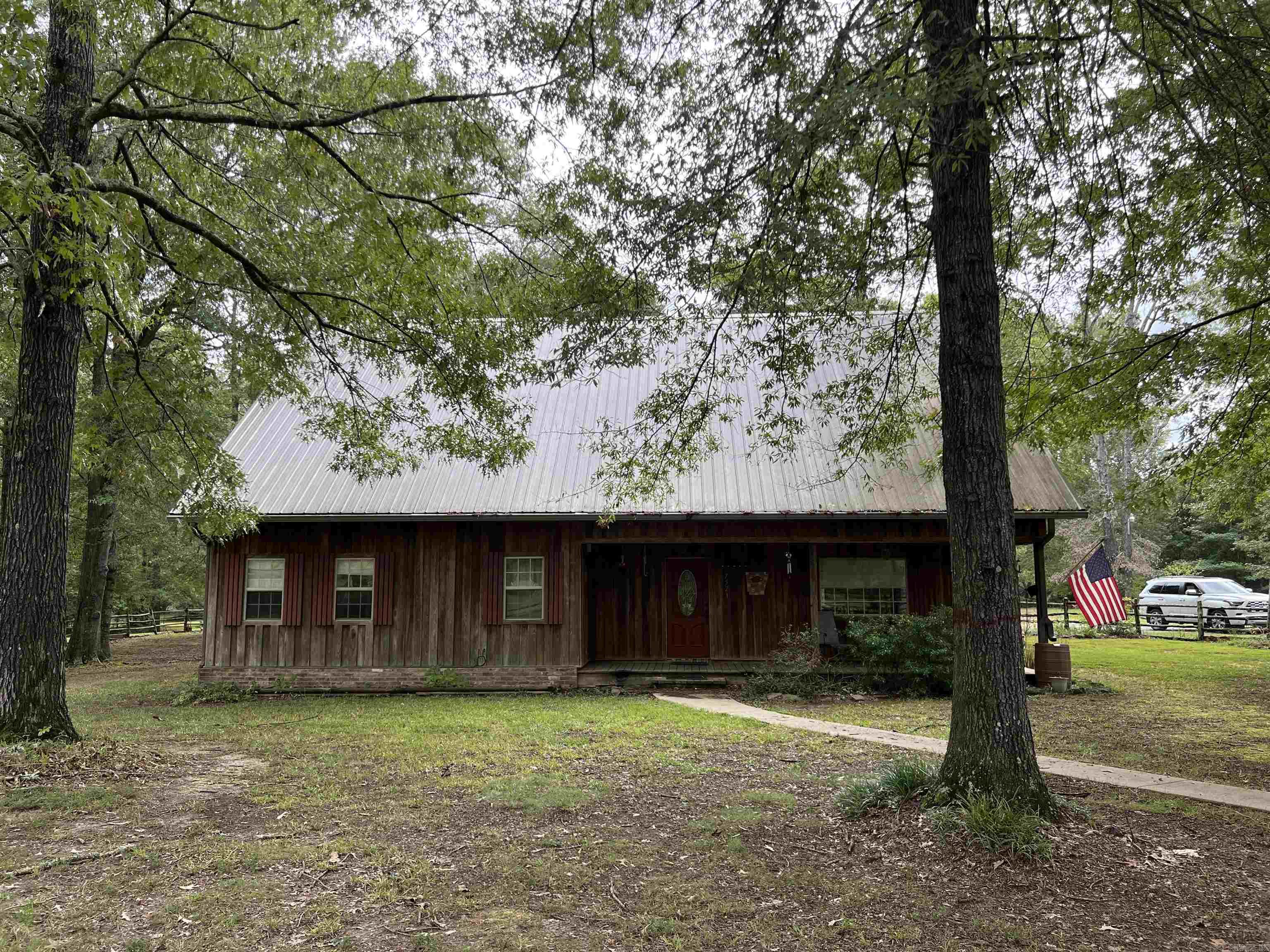 Looking for a beautiful home on acreage? Come see this two-story, 5 bed 2.5 bath home. This property is beautifully situated, offering serene views and plenty of privacy. The home is surrounded by lush greenery, with a stocked pond adding a touch of tranquility to the landscape.  The master suite is located on the main level and is a true retreat with a private bath and walk-in closet. Upstairs you will find the generous bedrooms, a full bath, sitting area between two of the bedrooms and a large area perfect for a sewing or reading area, or other options. The kitchen is a chef’s dream with modern appliances, ample counter space and cabinets and the open-concept design seamlessly connects the living room, dining area, and kitchen. A classic well-maintained barn stands nearby and with a little work could provide a separate living area with kitchen and bath. The barn has its own electrical meter and septic. Adjacent to the barn is a versatile shop space, ideal for DIY projects, storage, or as a workspace for various interests and is wired with a 220 for welding. The main home is also wired for a whole house generator. This home is a great blend of functional living and natural beauty.