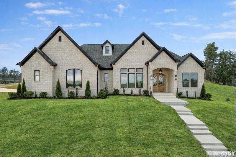 Welcome home to this stunning brand-new construction nestled inside a sought-after gated community on Lake Hamilton. Boasting 4 bedrooms, 3.5 bathrooms, and 3,474 square feet of thoughtfully designed living space, this home delivers the perfect blend of luxury, comfort, and lakeside lifestyle. Step inside to soaring spaces filled with natural light, where an inviting living room with built-ins and a gas fireplace sets the tone for effortless entertaining. The open kitchen is a chef’s dream, featuring a quartz island, breakfast bar, huge walk-in pantry, and an expansive dining area. Hardwood floors, designer lighting, and top-tier finishes flow throughout, making every corner of this home feel intentional and elevated. The primary suite is a true showstopper — cathedral ceilings, a spa-worthy freestanding tub, custom tile shower, and a massive walk-in closet that connects directly to the laundry room for ultimate convenience. Upstairs there is a versatile bonus room or additional bedroom with a full bath and private balcony overlooking the water. A green space across leads to the water, and the neighborhood boat launch means Lake Hamilton living is right at your fingertips!