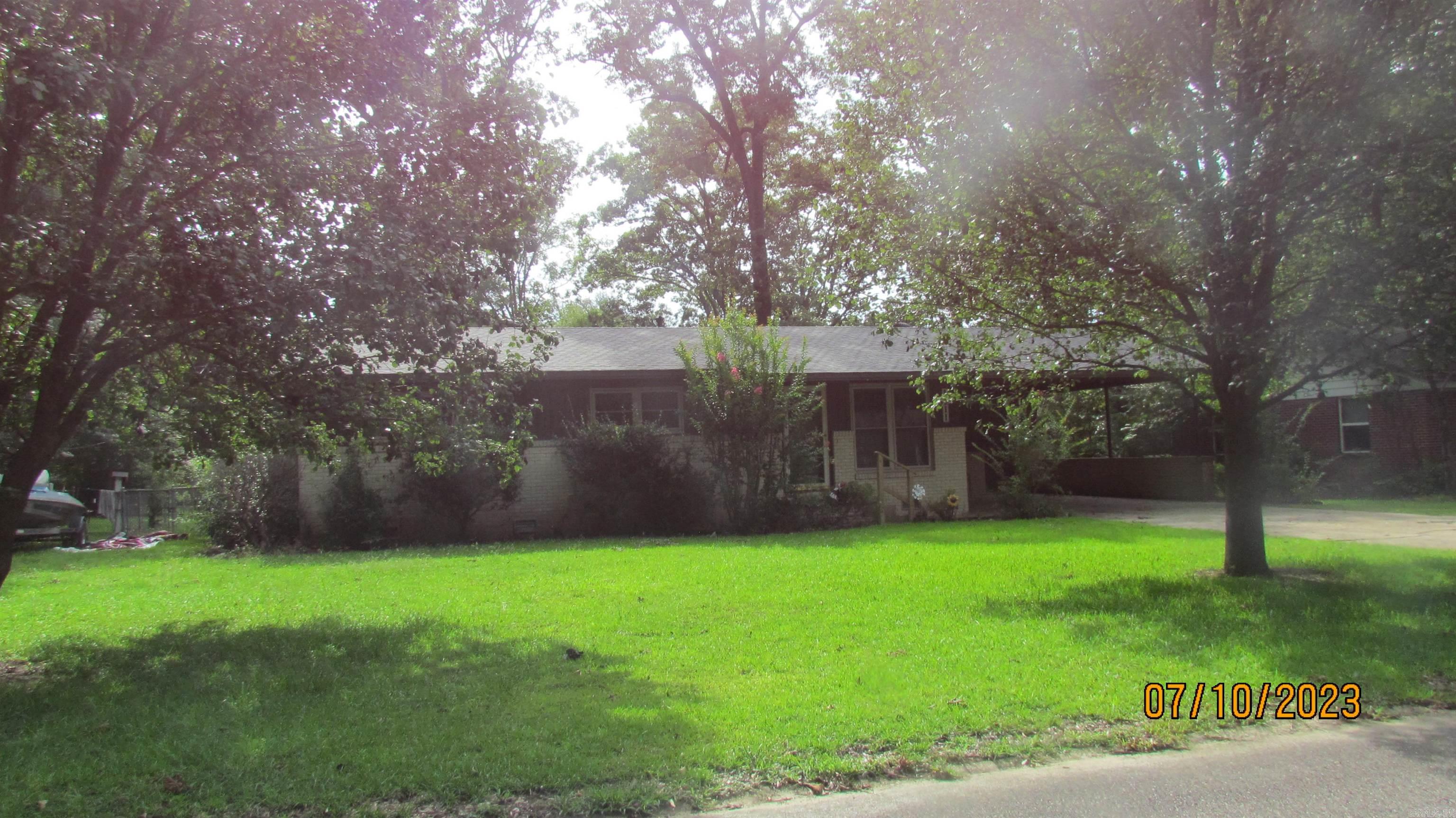 This lovely home features a formal living/dining room and a large den with a fireplace. (heater is in fireplace now hooked to gas making it easy to install gas logs) with vinyl flooring, a breakfast eating area,  kitchen with refrigerator and stove. Home also features three bedrooms, a hall bath with new walk-in shower, and a half bath.  Home has central heat and air, , laundry room in storage room off double carport, another storage room off carport, large fenced in yard with a large shop.