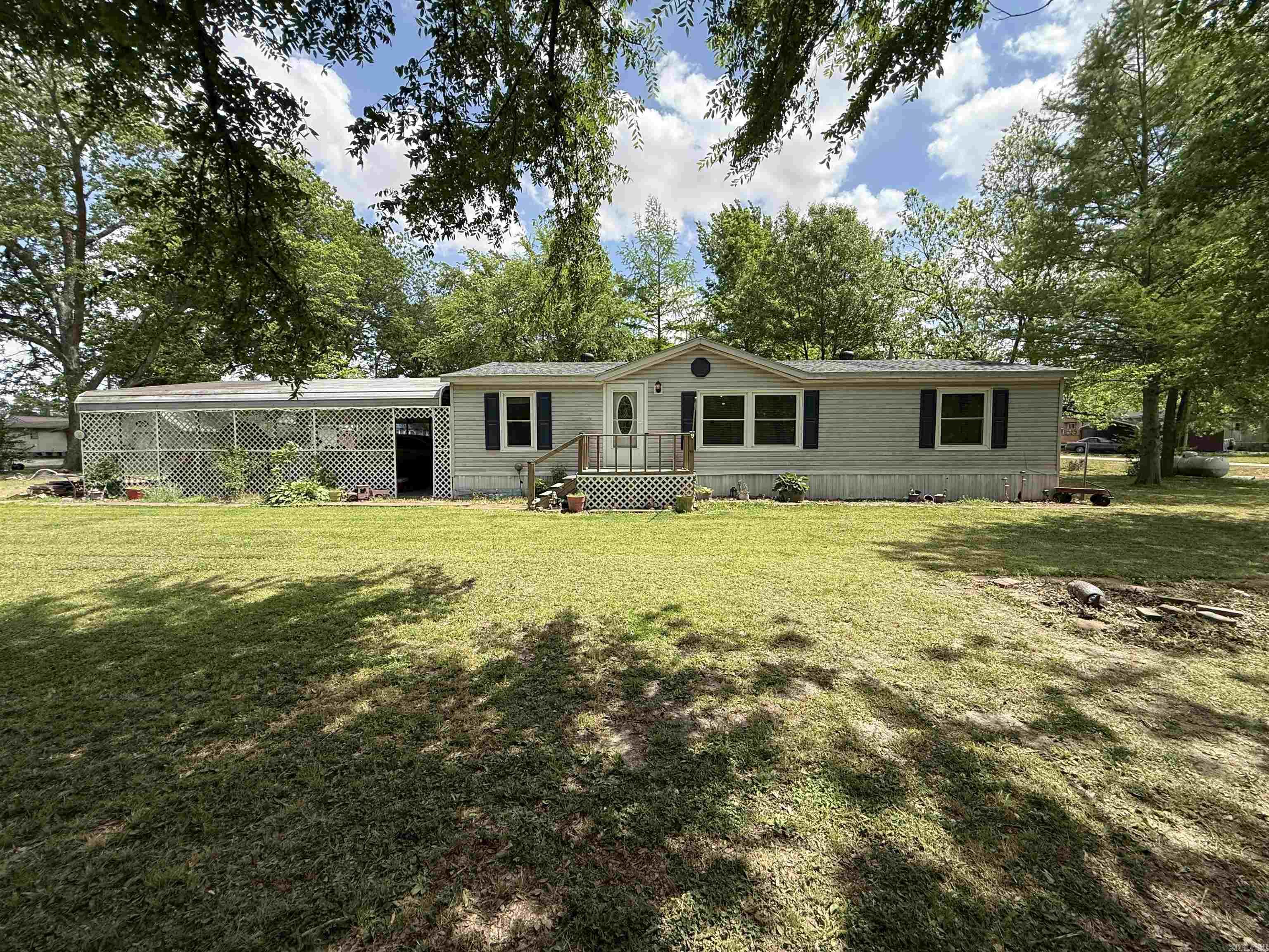 This country home, situated on nearly half an acre, has it all.  Highlights include a whole-home Generac generator, a wheelchair ramp, a screened-in back porch, an extended mudroom, a to-die-for pantry, and three storage sheds—one equipped with both 110 and 220 hookups. Additionally, there is a metal carport that accommodates up to six vehicles. The kitchen and both bathrooms have been updated, complemented by new flooring throughout. Seller put on a new roof, updated windows, doors, lighting fixtures, and ceiling fans.  Location would make the perfect hunting cabin or a permanent residence. Home is NOT in the flood zone, and flood insurance is not required.