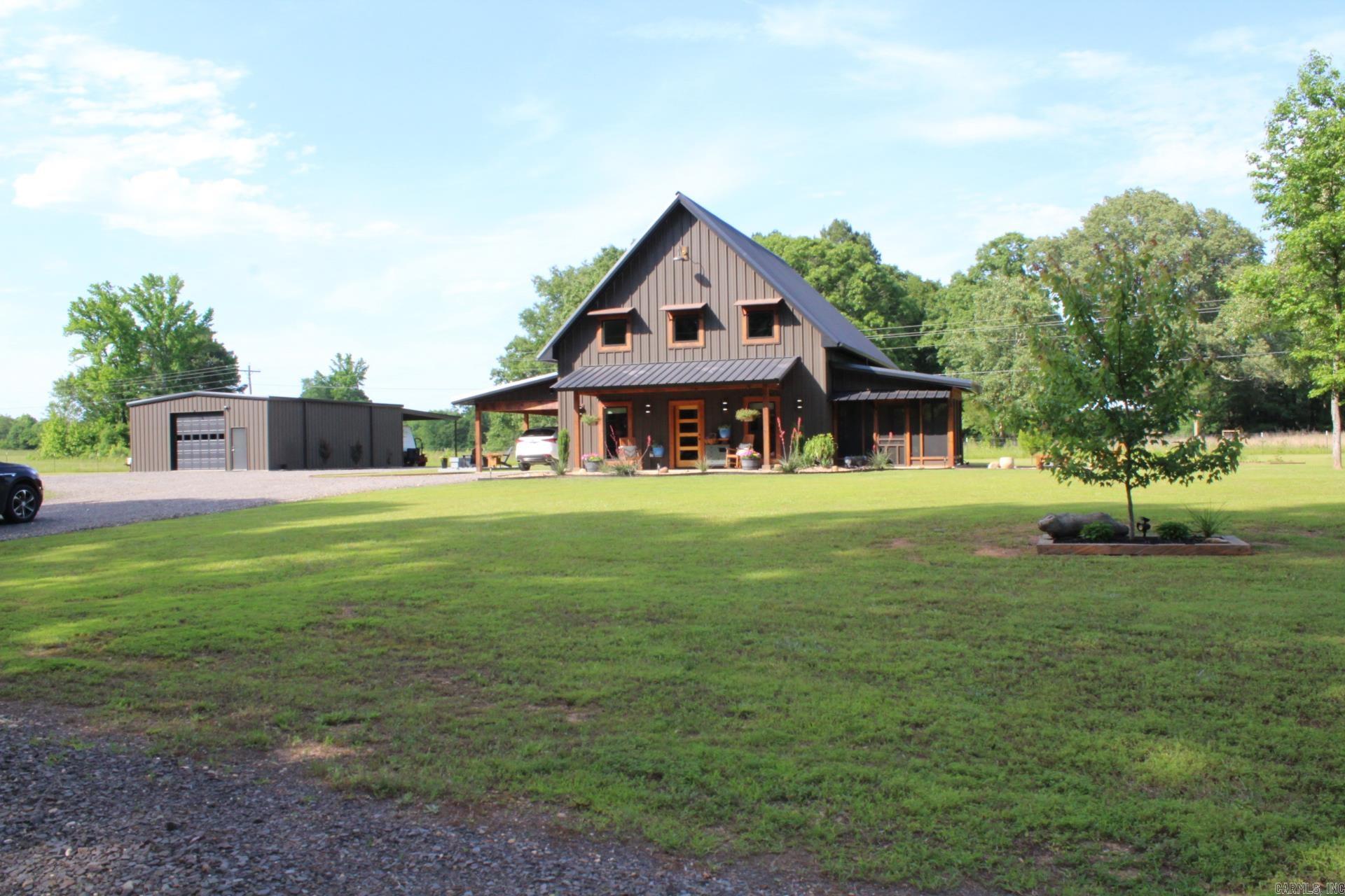 Discover the perfect balance of rustic charm and modern comfort in this beautifully designed Barndominium set on 2 peaceful acres with approx. 1740 Sq. Ft. of  thoughtfully planned living space, it offers an open, airy feel that's ideal for both everyday living and easy entertaining.  Enjoy the freedom of wide-open space while still having the finishes and features today's buyers love.  Gourmet kitchen with Quartz countertops (Range, dishwasher and refrigerator convey with sell of home.)  Spacious family area features a electric fireplace. 9 ft. vaulted ceilings. Step out to the screened-in porch to unwind with morning coffee or host friends for relaxed evenings outdoors.  Central A/C & Heat.  The 30 x 40 shop/workshop adds incredible versatility, whether you need a place for hobbies, projects, equipment, or extra storage.  Beautifully landscaped grounds.