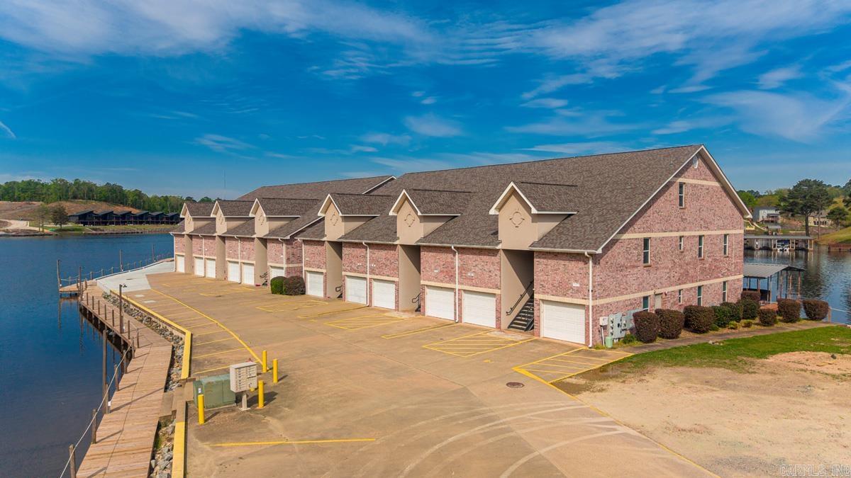 WOW! What an awesome experience you will have in this stunning 2 bedroom - 2 bath condo overlooking beautiful Lake Hamilton in Hot Springs!! This residence combines modern elegance with breath taking views, making it the perfect retreat for tranquility & leisure.  Step inside to discover an open layout adorned with large windows allowing natural light to fill the space & showcase the picturesque lake views! Enjoy your morning coffee on your patio. Jump into your boat at your own private boat dock to soak in the stunning sunrise or unwind in the evenings watching the colorful sunsets. This walk in level condo with its own garage is not just a property but will be your lifestyle of comfort, convenience & scenic beauty all around. Investment opportunity also since it can be a rental. Everything Remains! Don't miss the opportunity to make this lakeside gem your own! Close to Oaklawn and all that Hot Springs has to offer! Agents see remarks